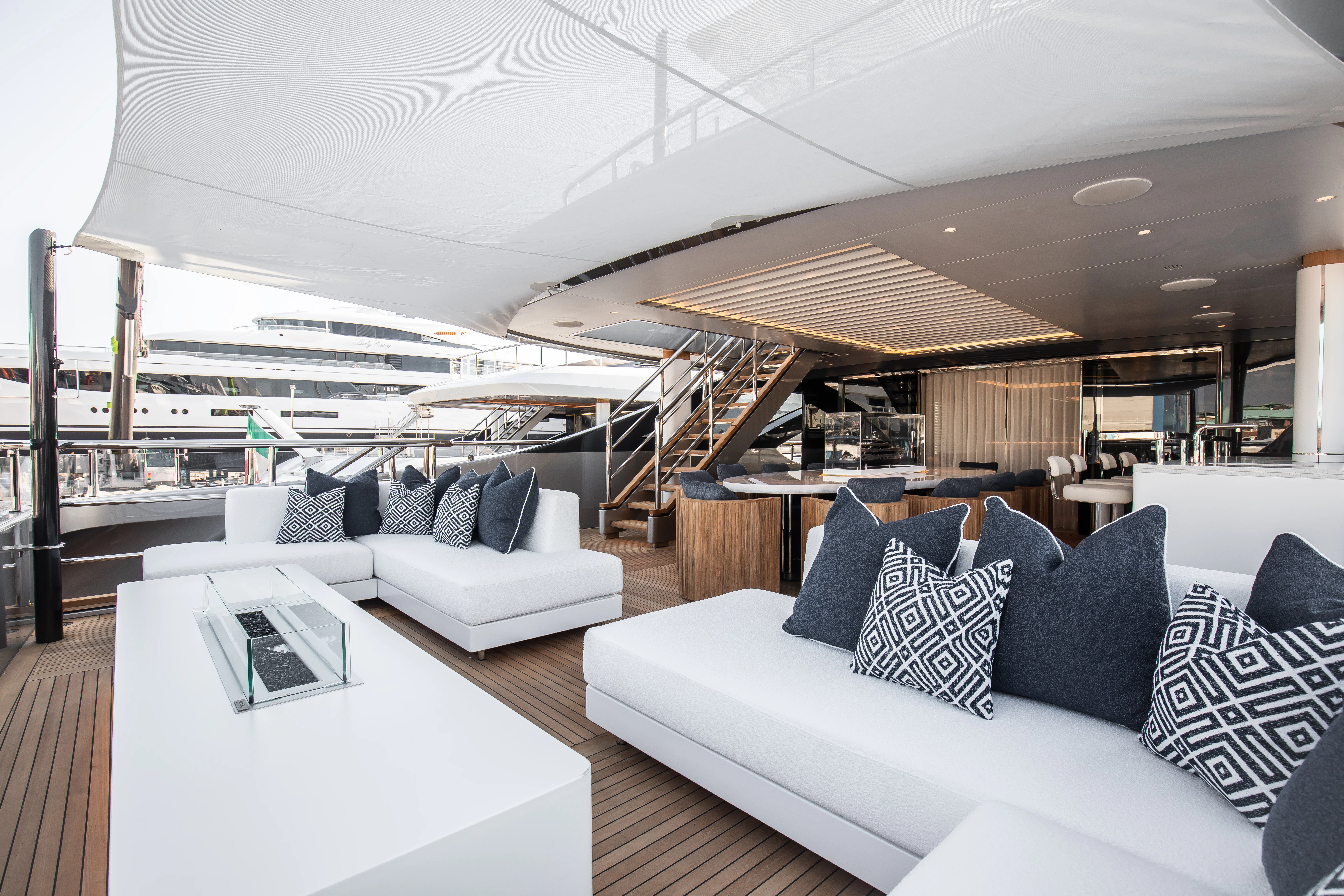 a modern living room with a large white sofa and a white table aboard PERSEVERANCE Yacht for Charter