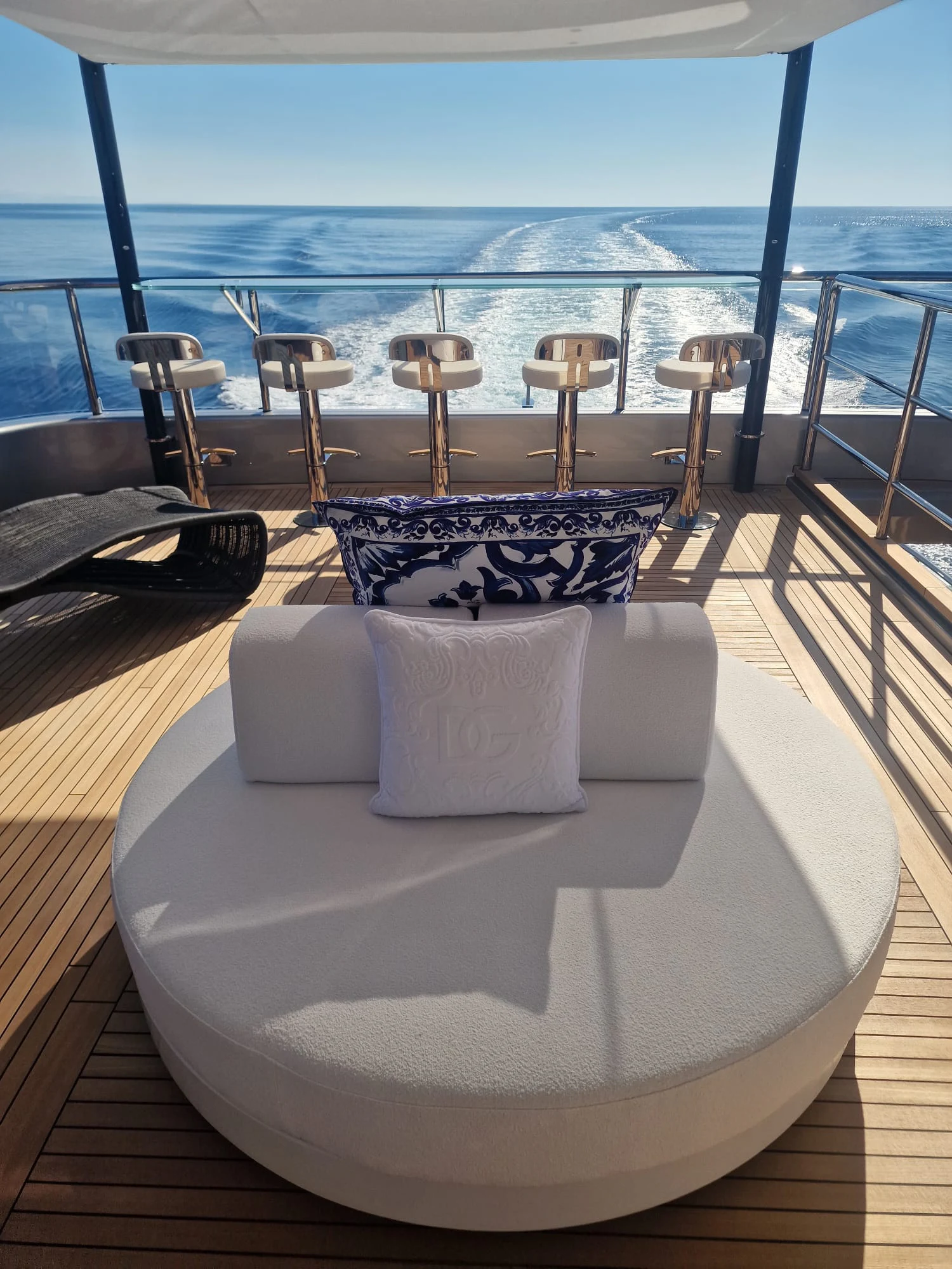 a large white bed with a blue ocean behind it aboard PERSEVERANCE Yacht for Charter