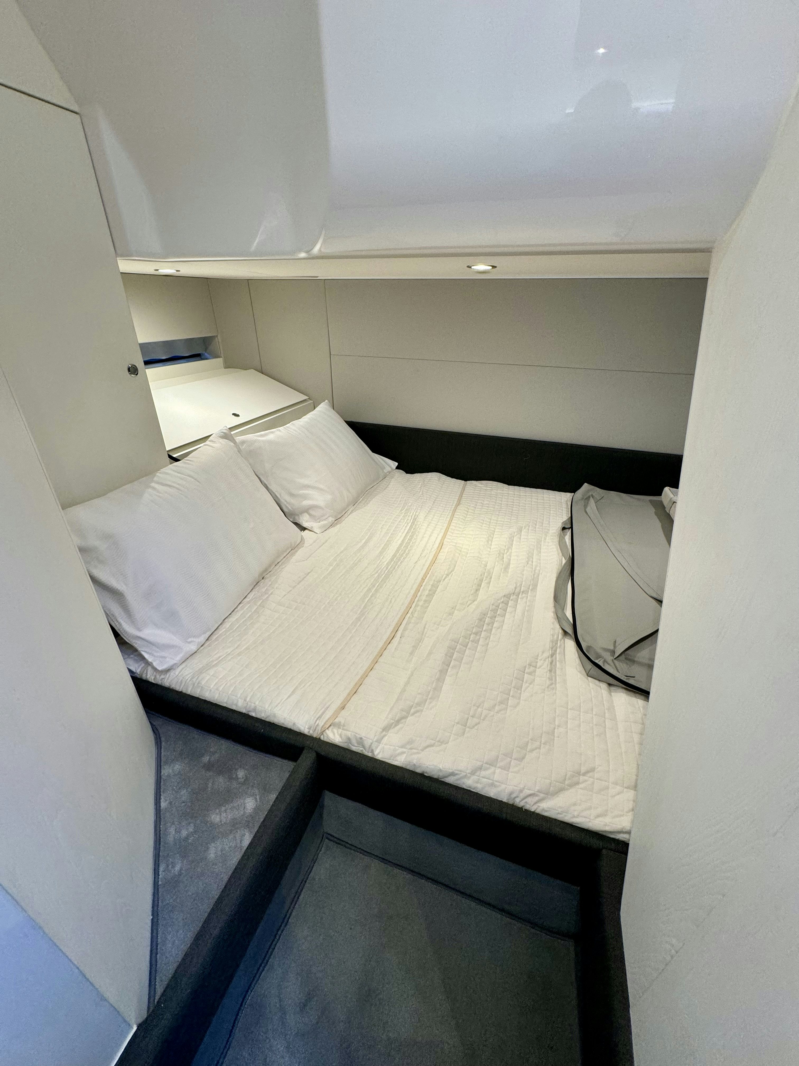 a bed with white sheets aboard GG Yacht for Sale