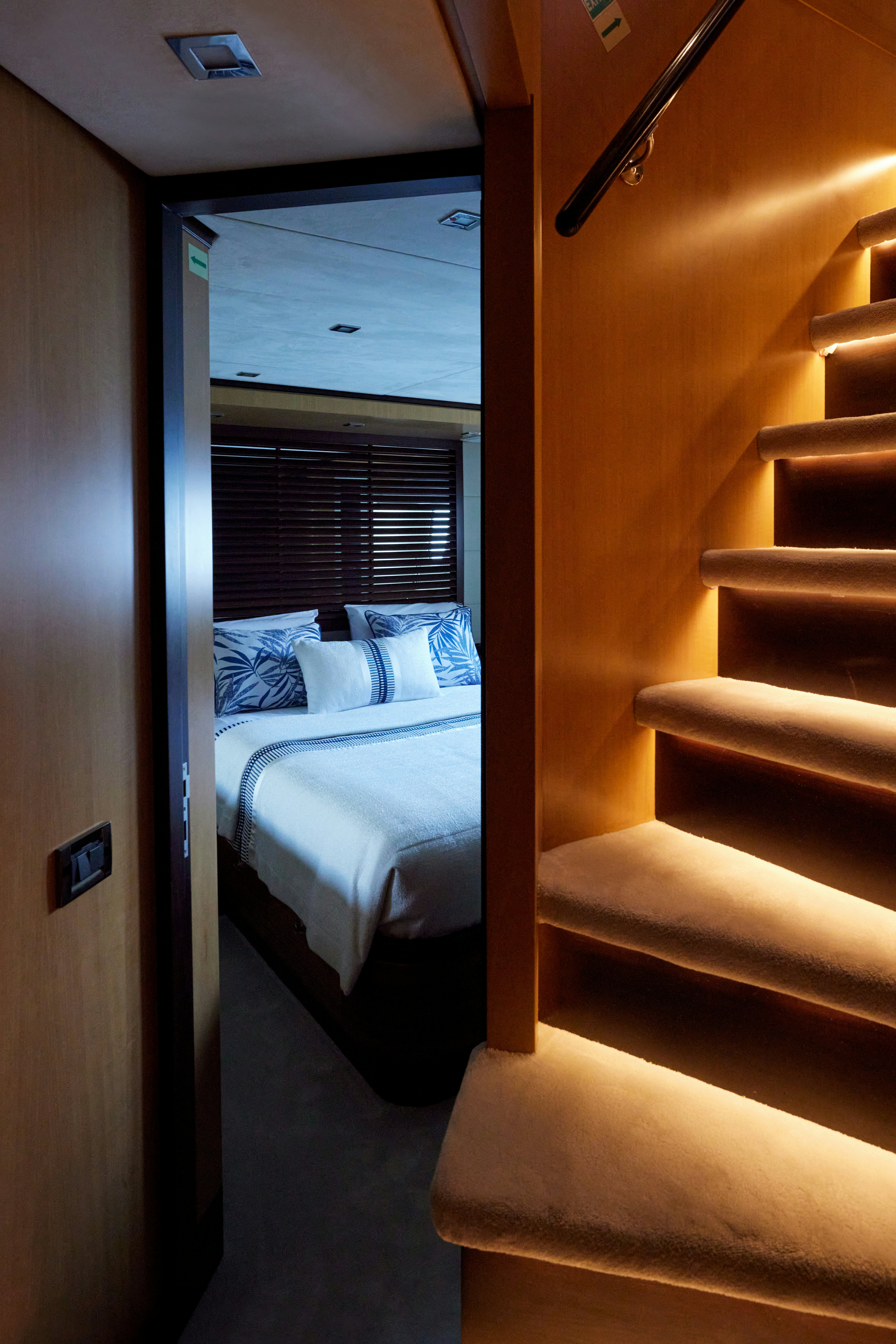 a bed with a white sheet and a wooden door aboard AYSHA Yacht for Sale