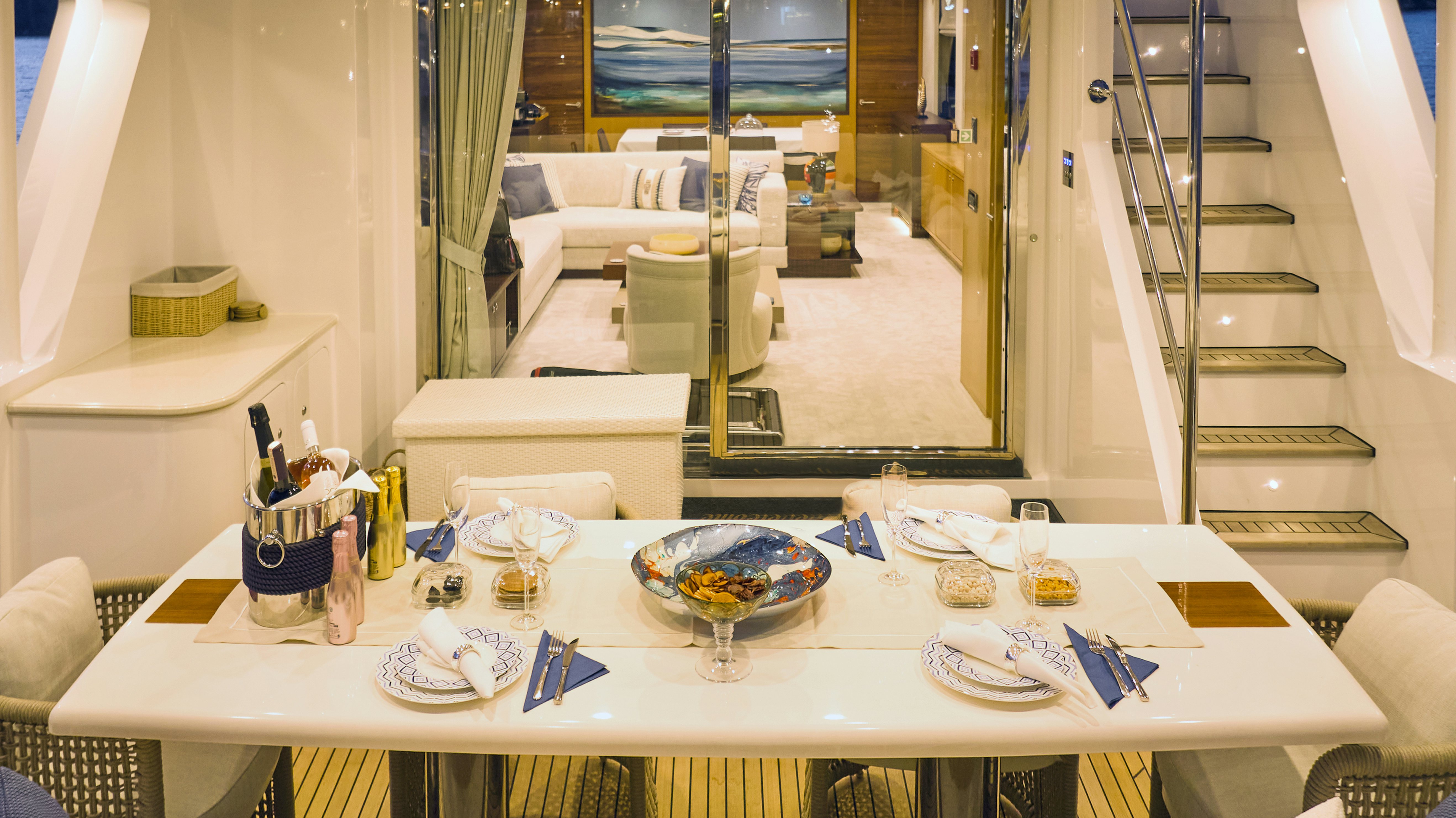 a table with plates and glasses aboard AYSHA Yacht for Sale