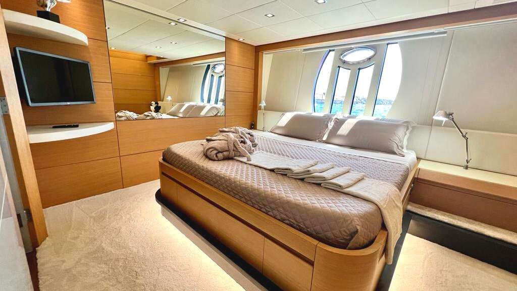 a room with a bed and a television aboard THYKE II Yacht for Charter