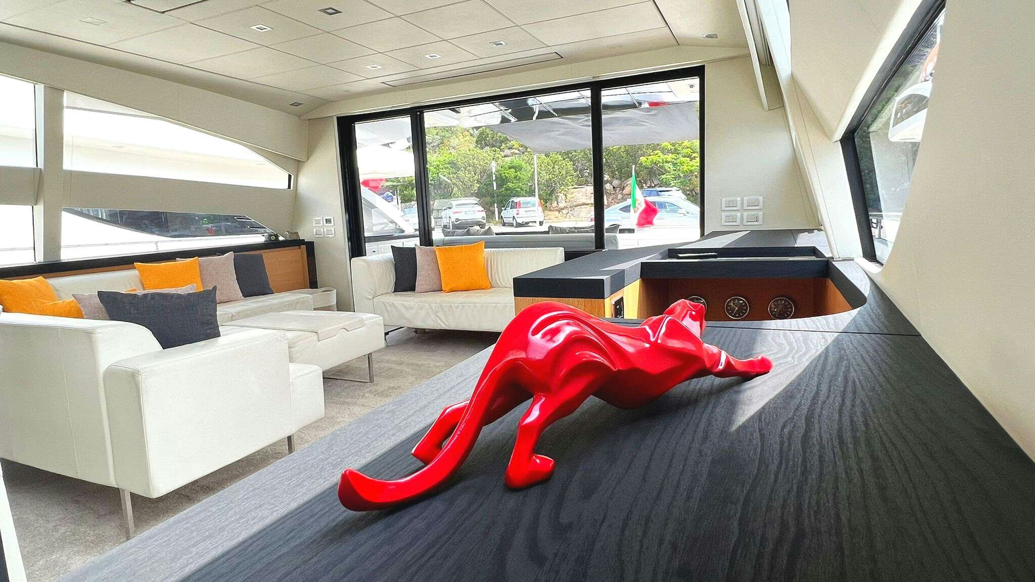 a person lying on a bed in a room with a large window aboard THYKE II Yacht for Charter