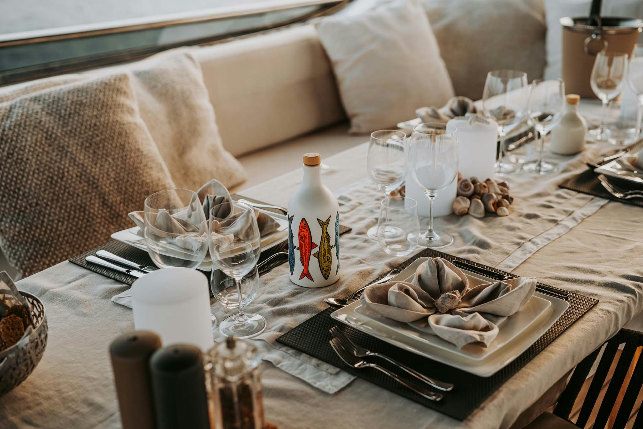 a table with a plate of food and bottles of wine aboard VENUS Yacht for Charter