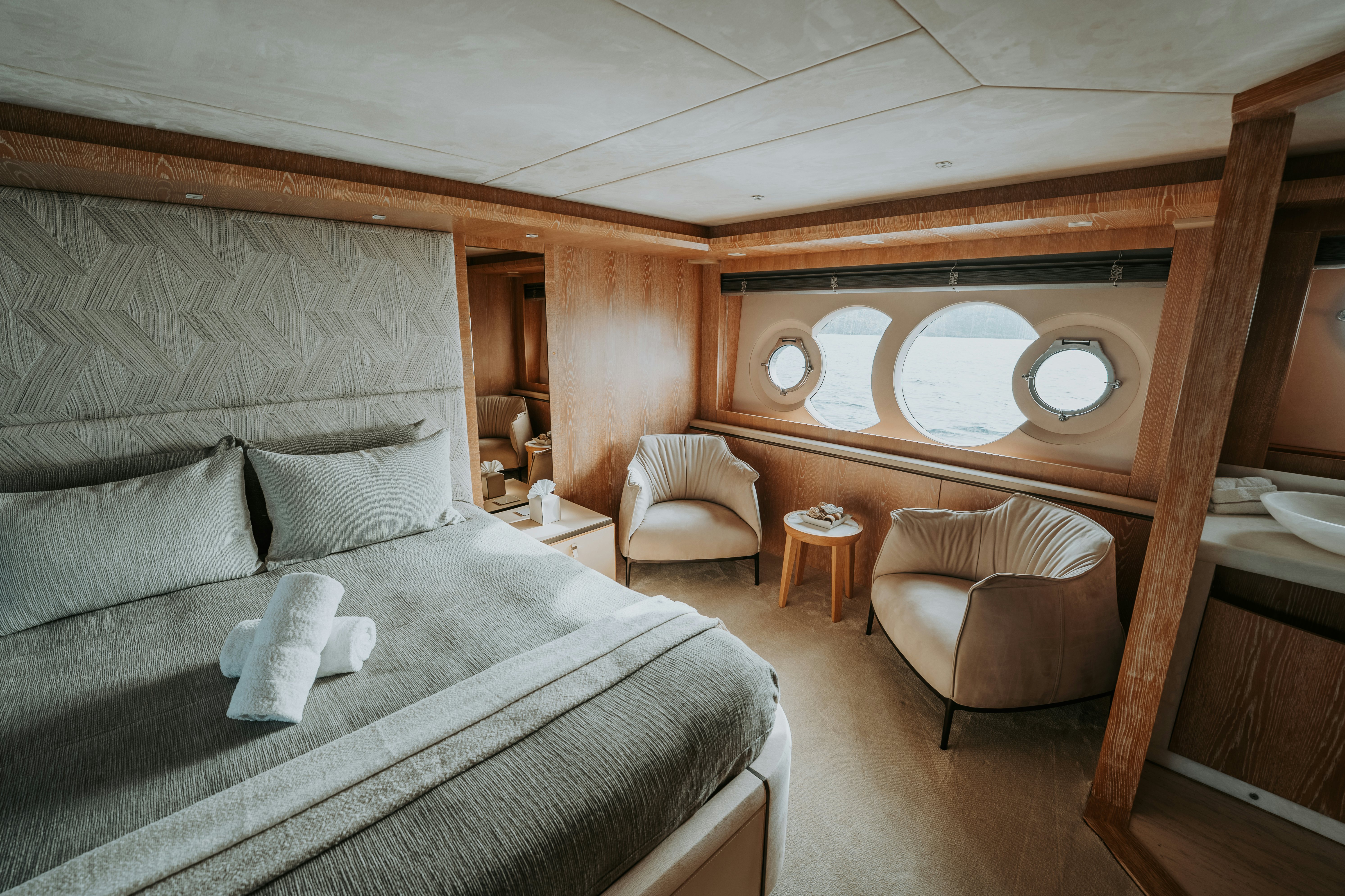 a room with a bed and a chair aboard VENUS Yacht for Sale