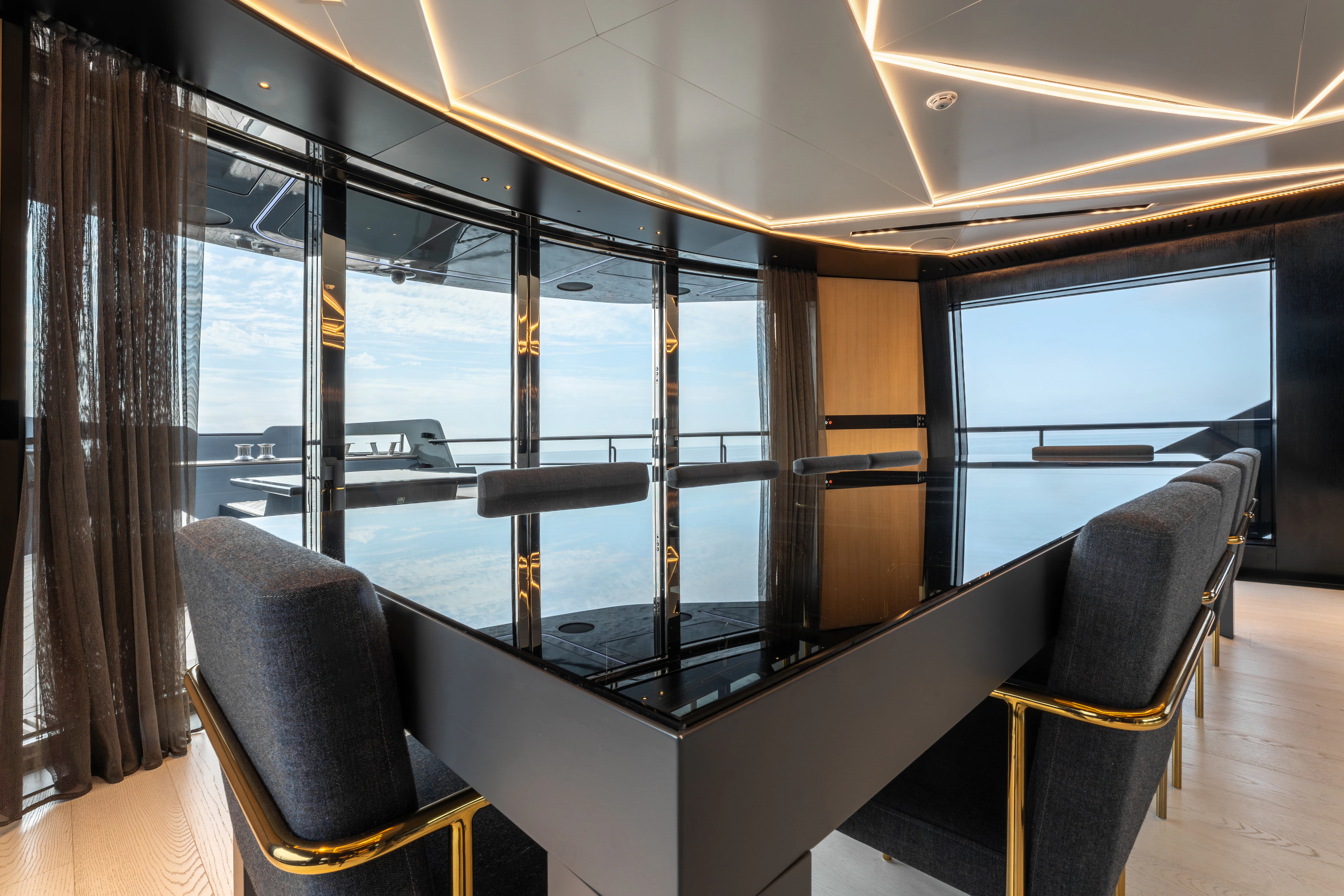 a room with a large table and chairs and a large window aboard K+ Yacht for Sale