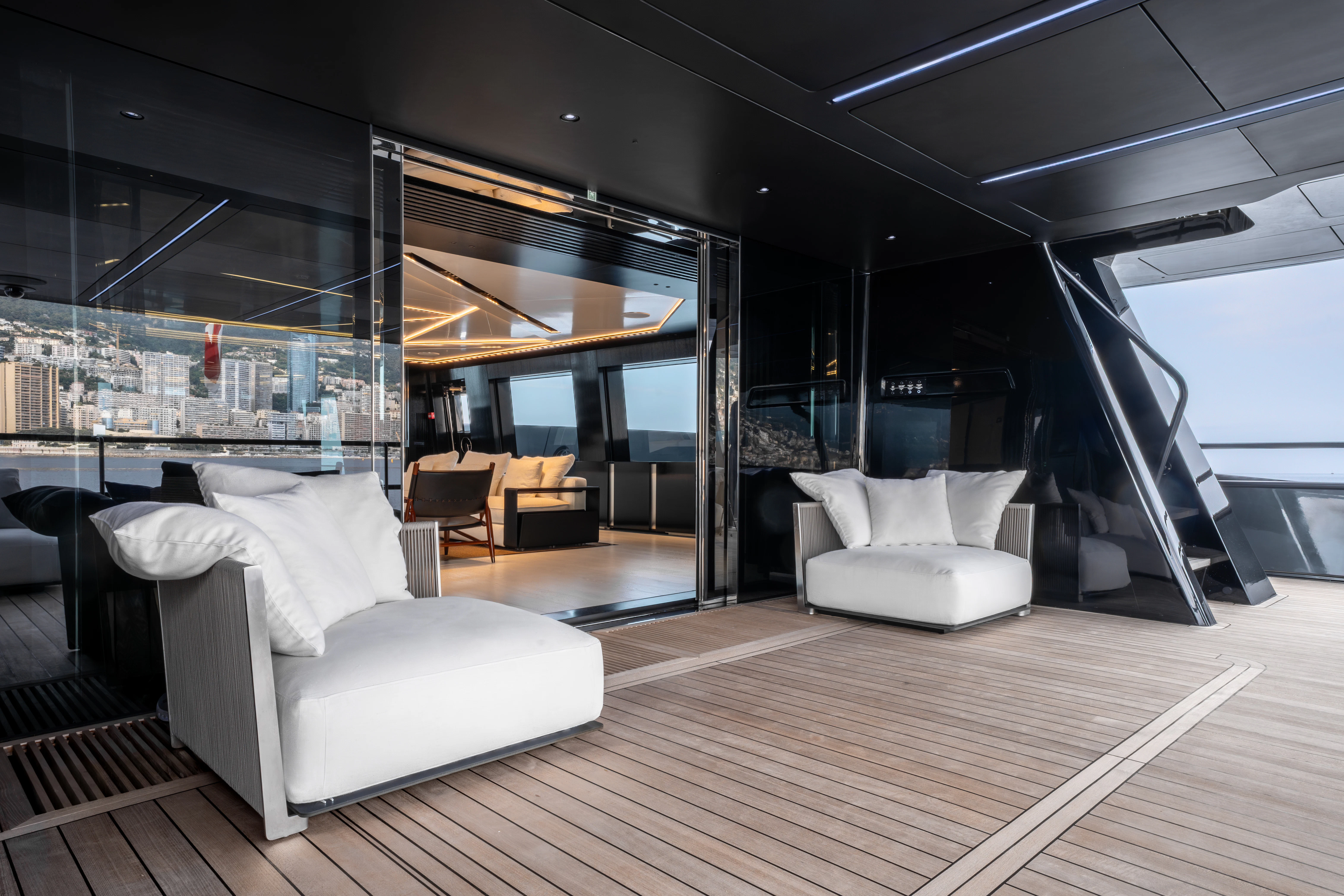 a room with a wood floor and white couches aboard K+ Yacht for Sale