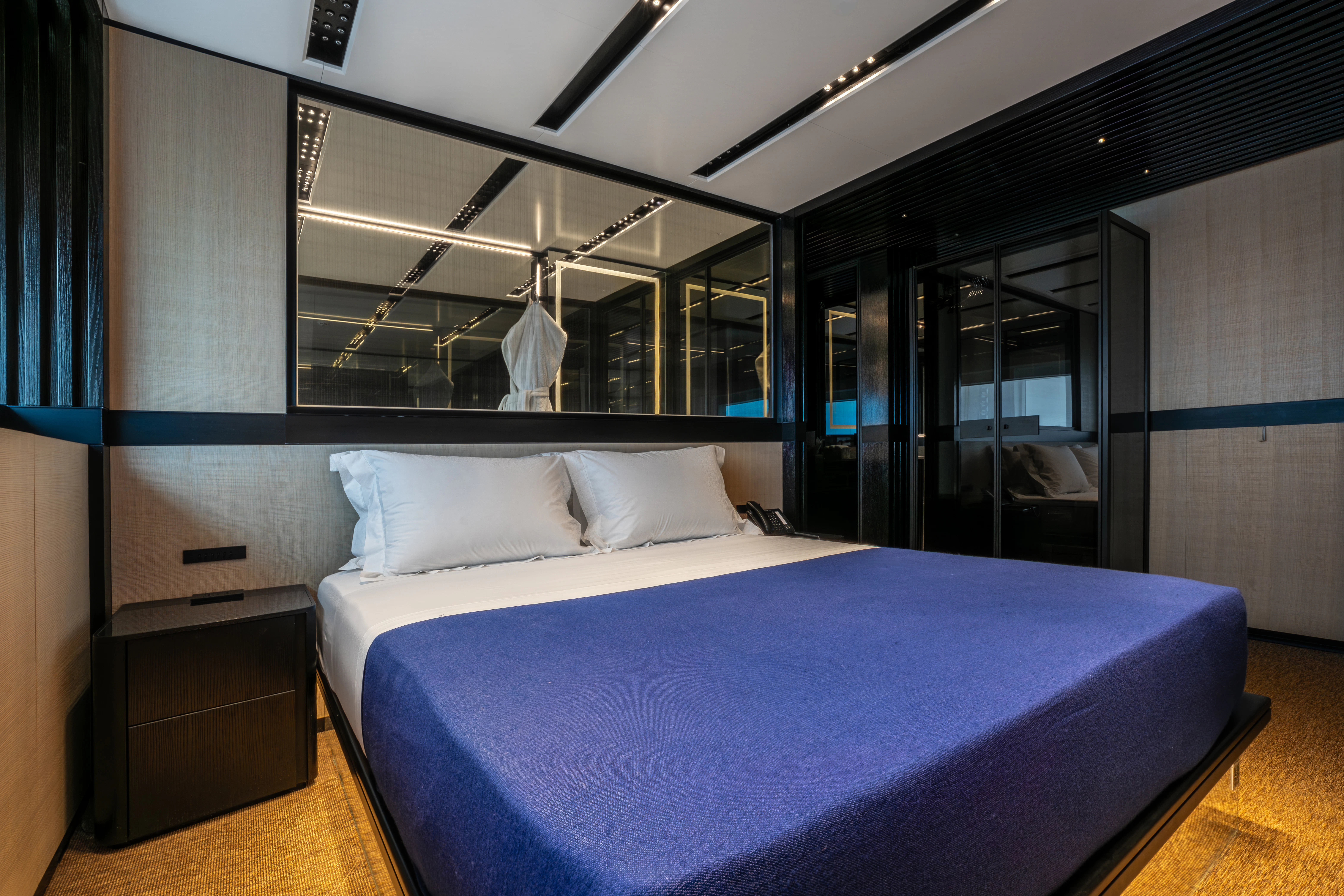 a bedroom with a blue bed aboard K+ Yacht for Sale