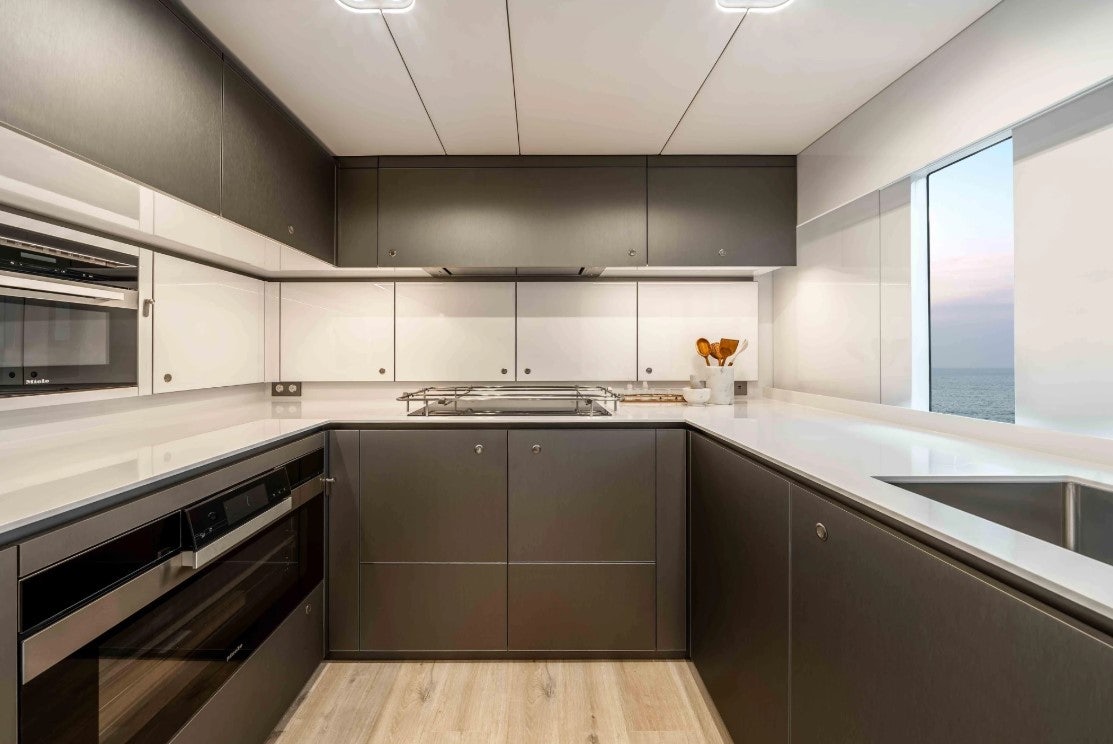 a kitchen with black cabinets aboard AMITATU Yacht for Charter