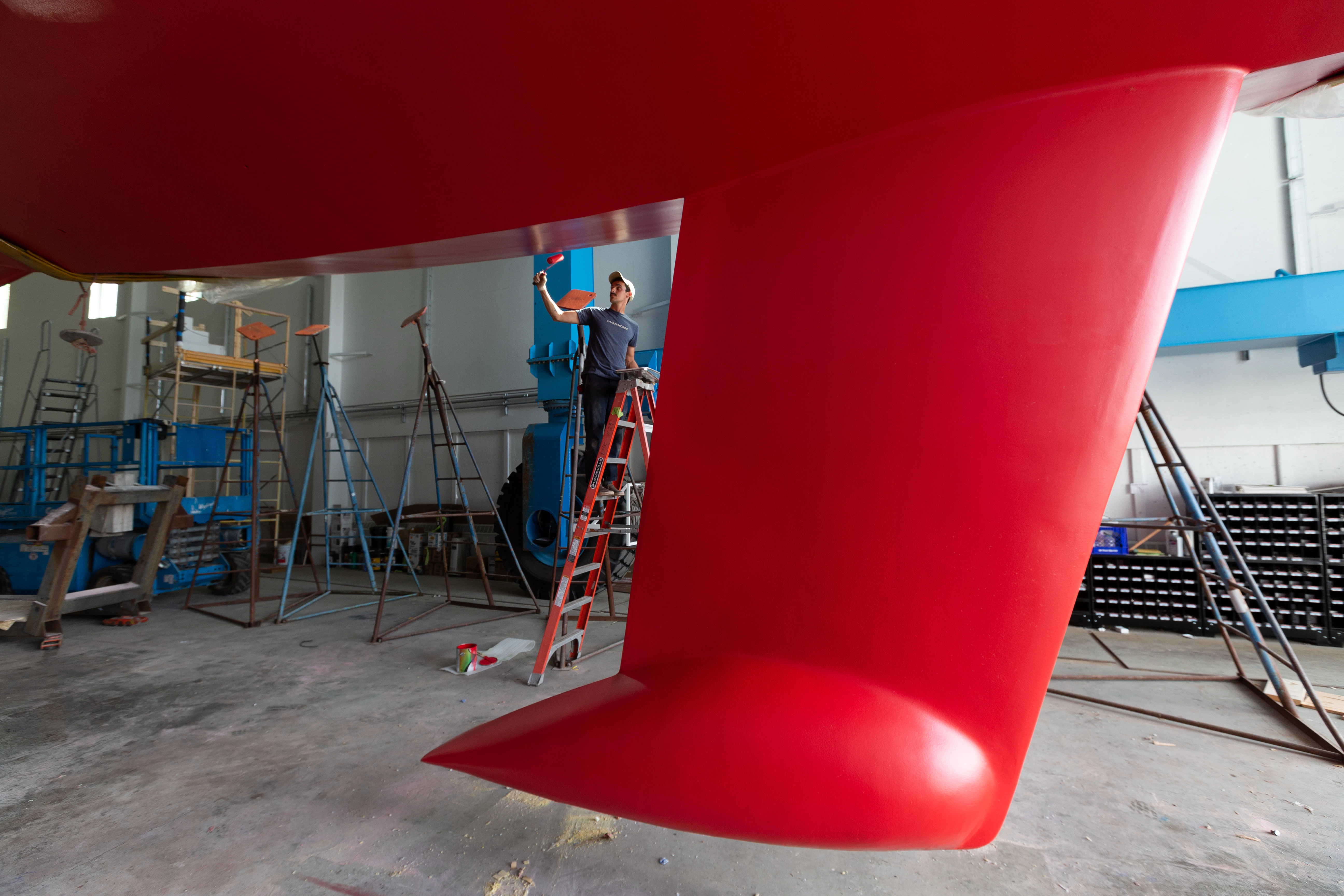 a person on a ladder in a room with a red slide aboard FALCON Yacht for Sale