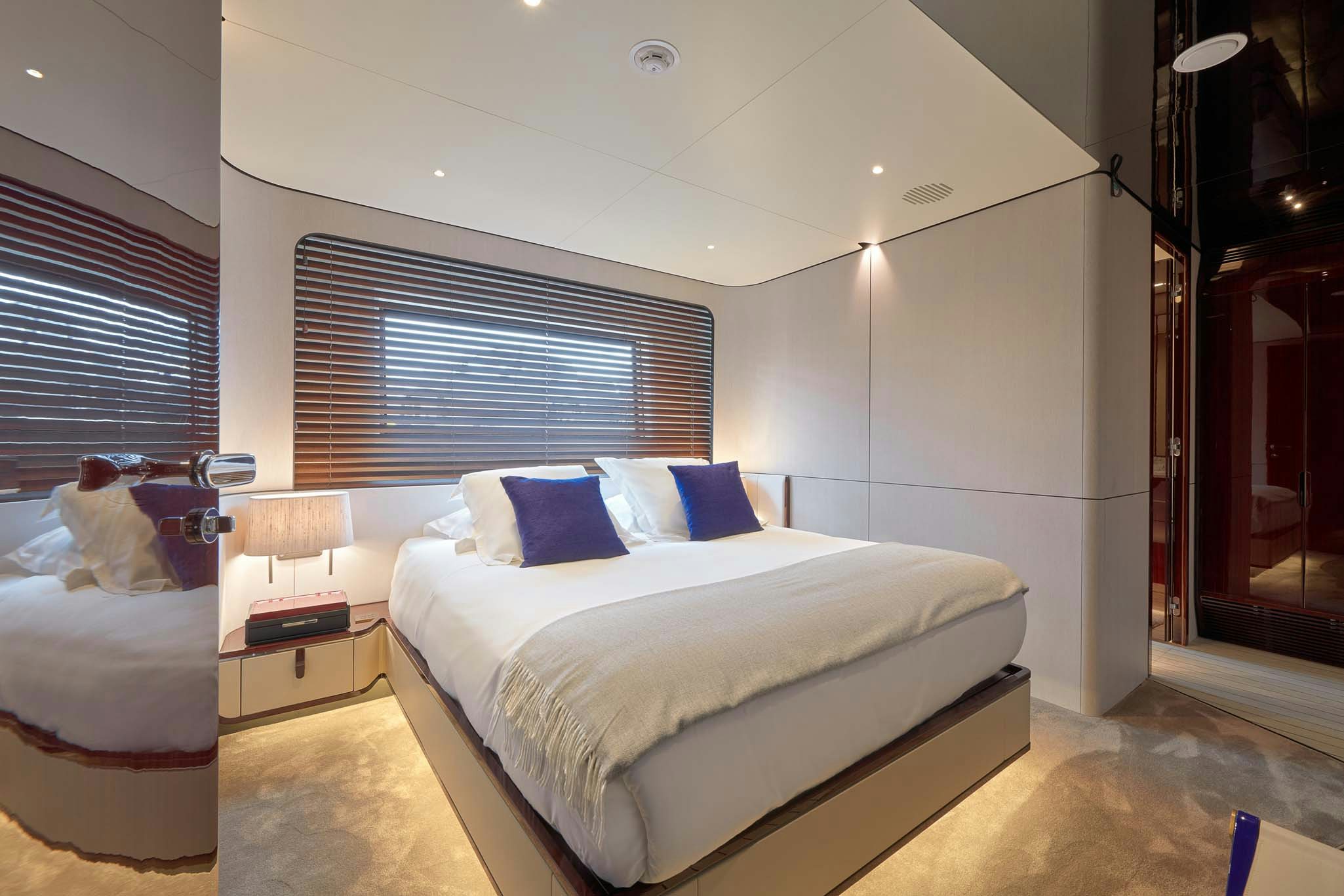 a room with a bed and a mirror aboard HEED Yacht for Charter