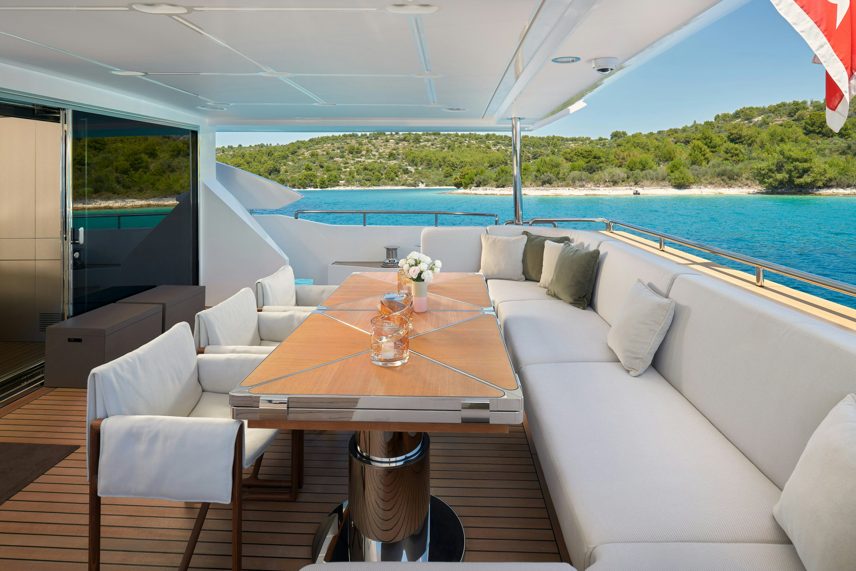 a table and chairs on a deck aboard HEED Yacht for Sale