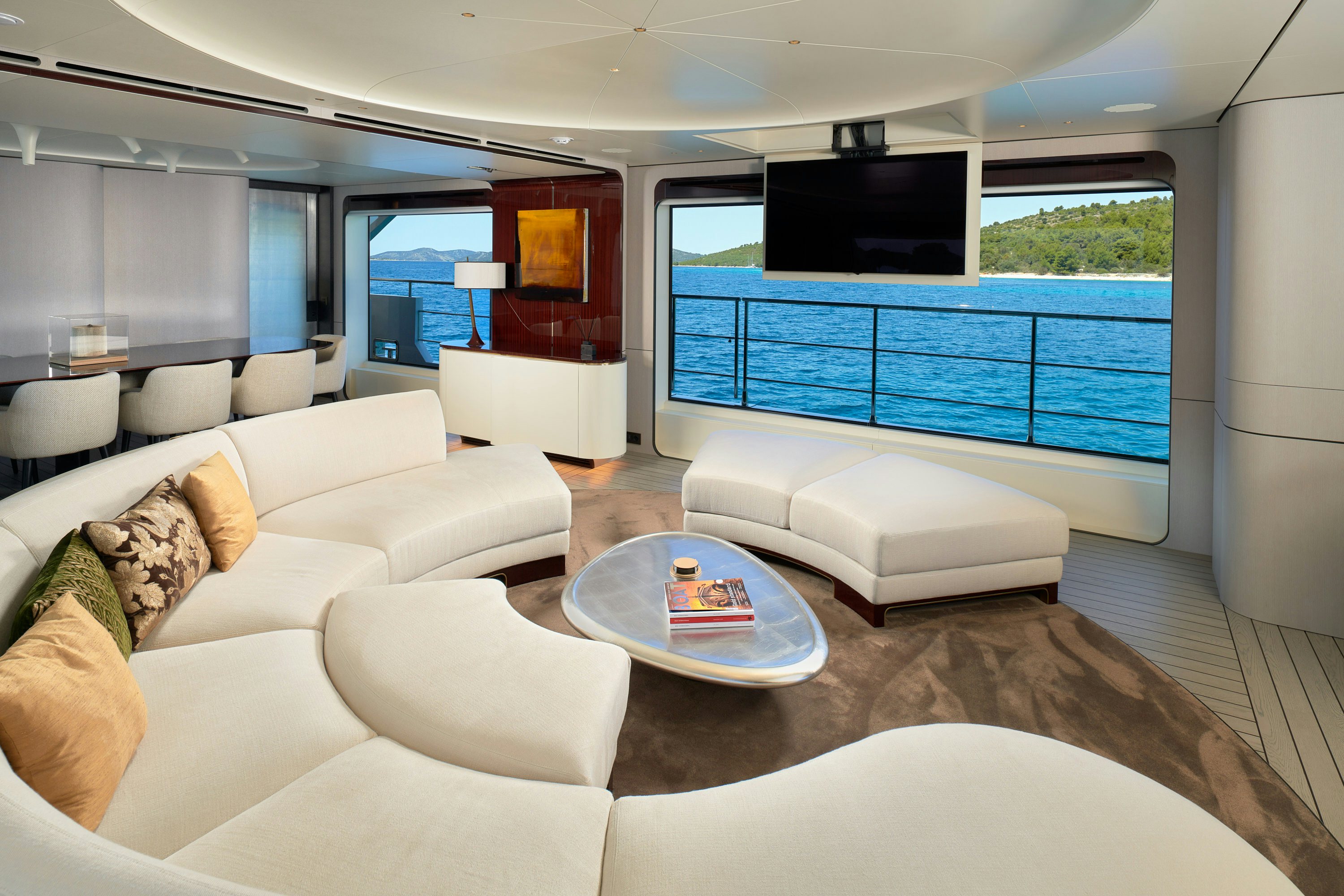 a living room with a large blue glass wall aboard HEED Yacht for Sale