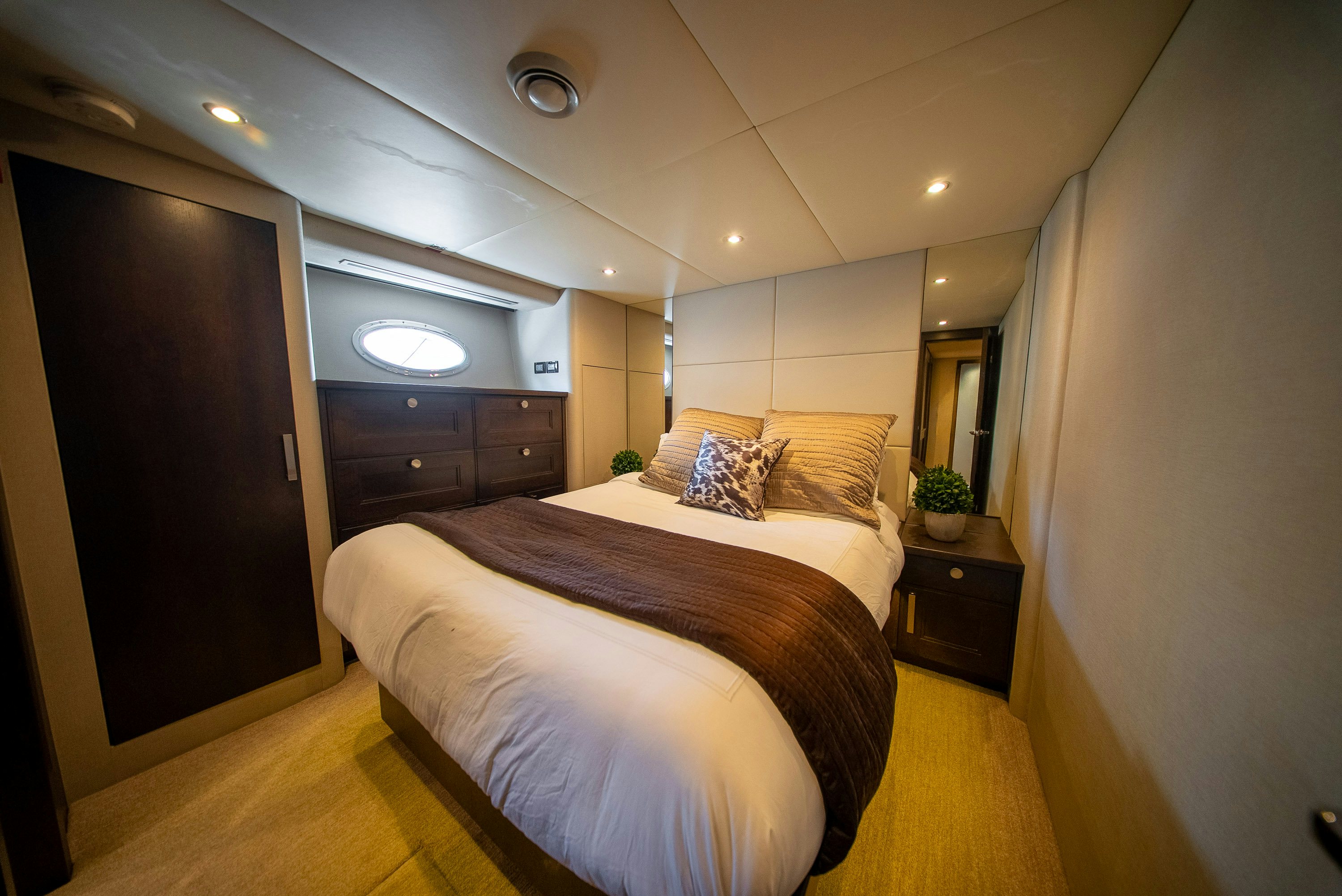 a bedroom with a bed and a mirror aboard ENCORE Yacht for Sale