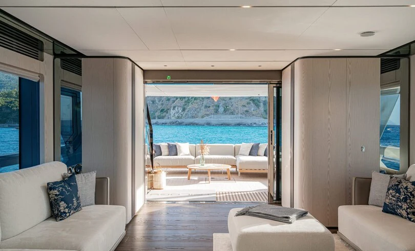 a living room with a large blue ocean aboard TRILOGY Yacht for Charter