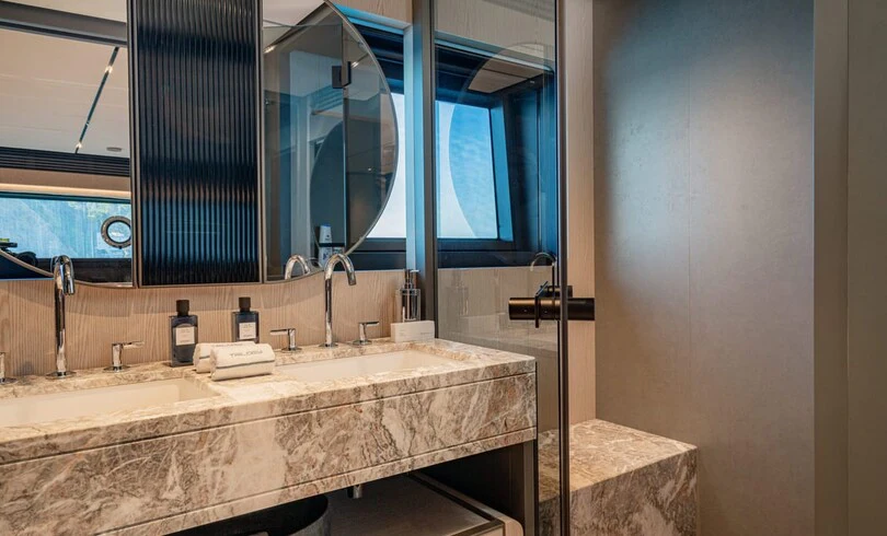 a bathroom with a countertop sink and a large mirror aboard TRILOGY Yacht for Charter