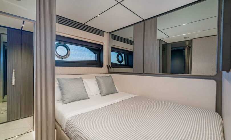 a room with a bed and a television on the wall aboard TRILOGY Yacht for Charter