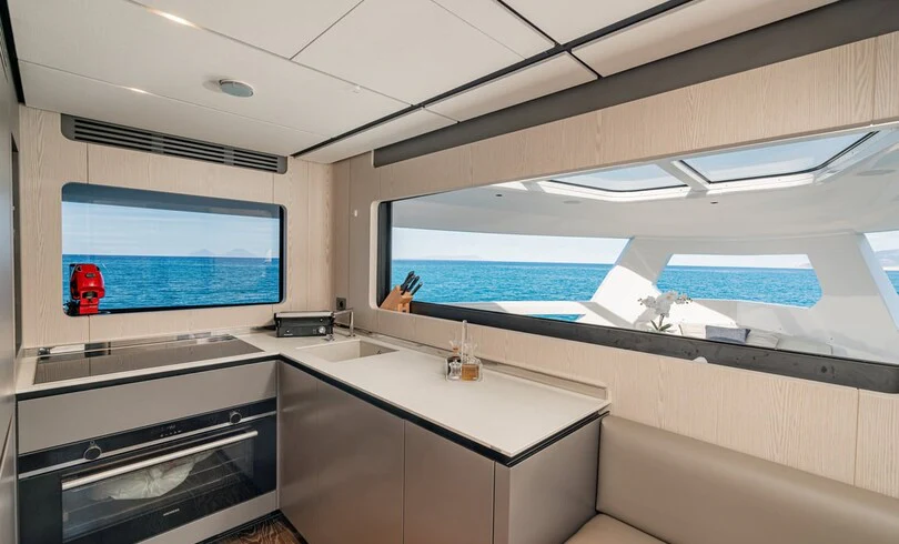 a kitchen with a large window aboard TRILOGY Yacht for Charter