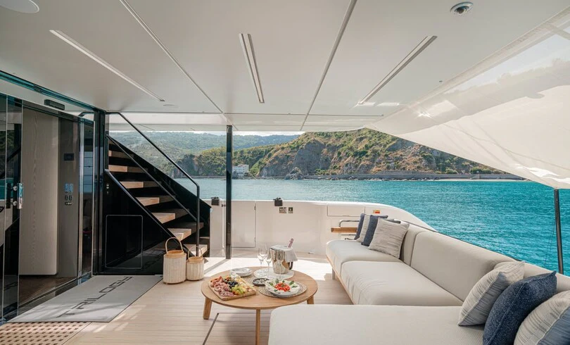 a living room with a large balcony aboard TRILOGY Yacht for Charter