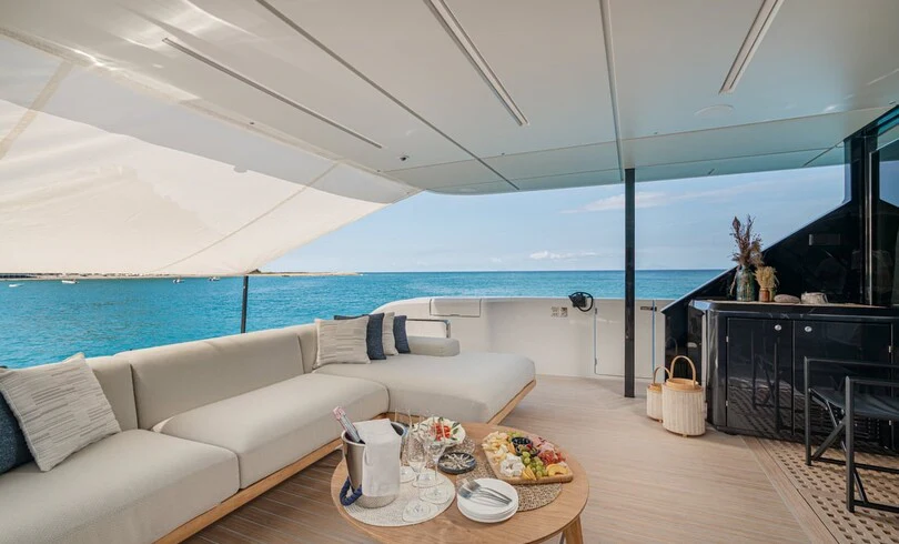a living room with a large balcony aboard TRILOGY Yacht for Charter