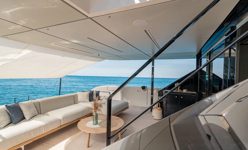a room with a couch and a table and a large window aboard TRILOGY Yacht for Charter
