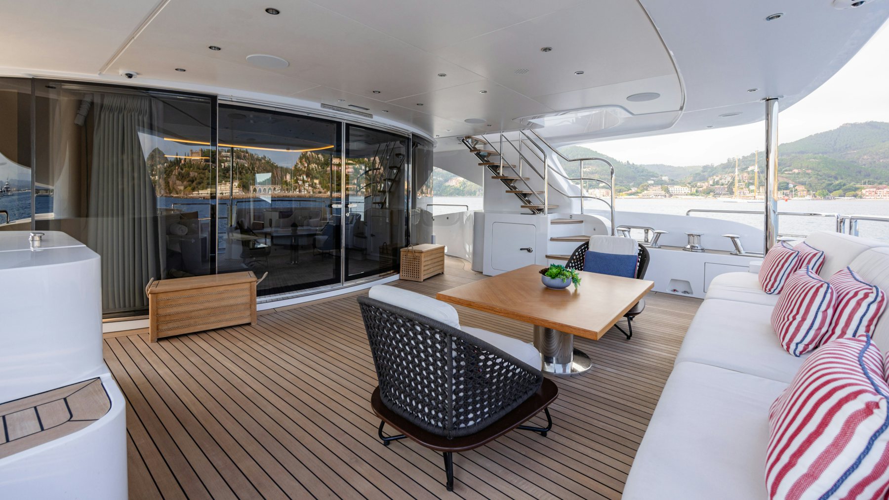 a living room with a large glass door and a wood table aboard BELLA VITA Yacht for Sale