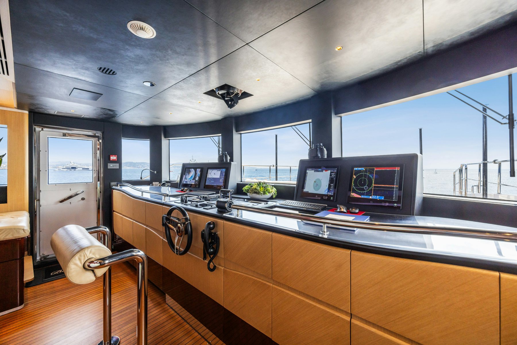 a kitchen with a bar and a table with chairs aboard BELLA VITA Yacht for Sale