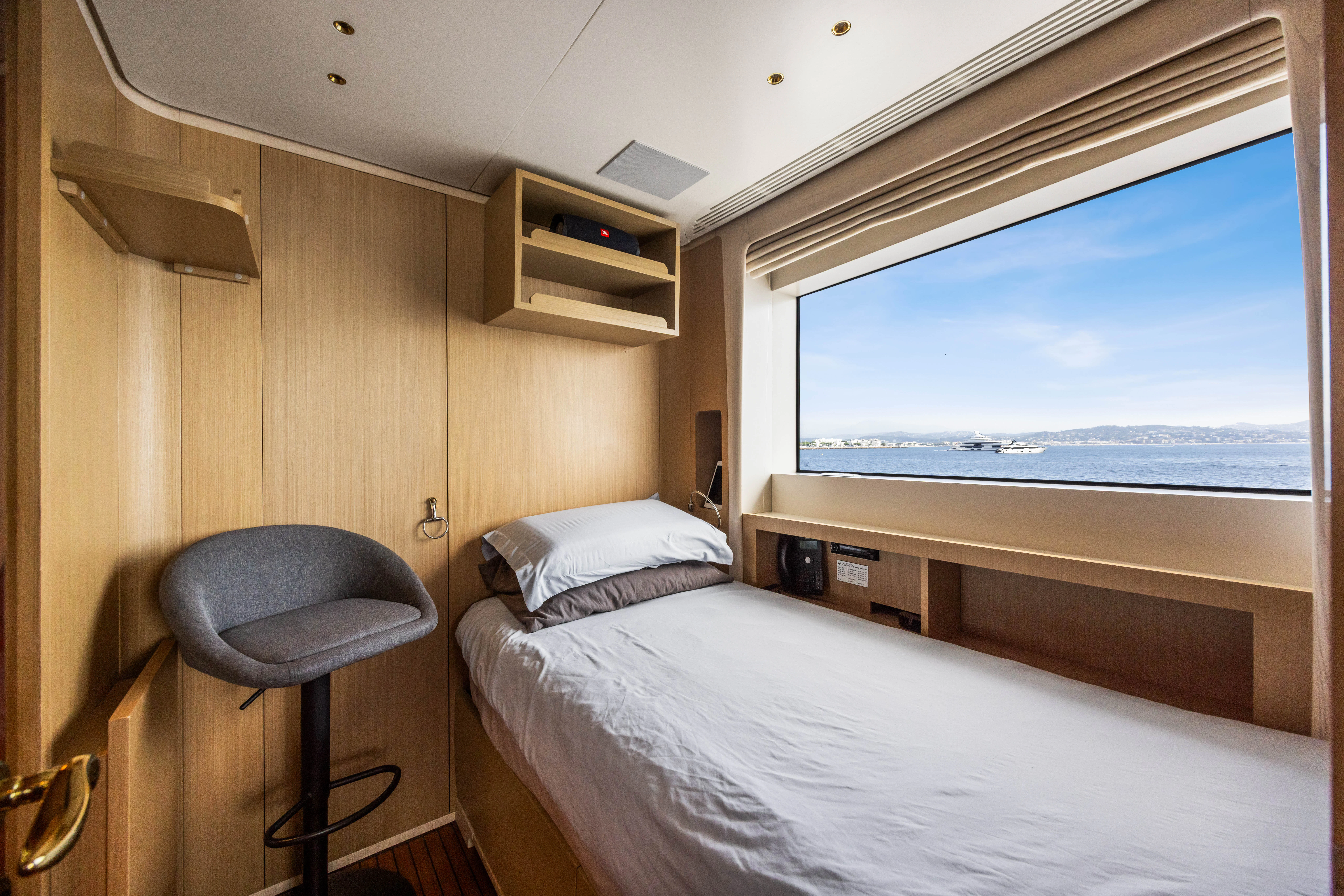 a room with a bed and a chair aboard TRAMONTO Yacht for Charter