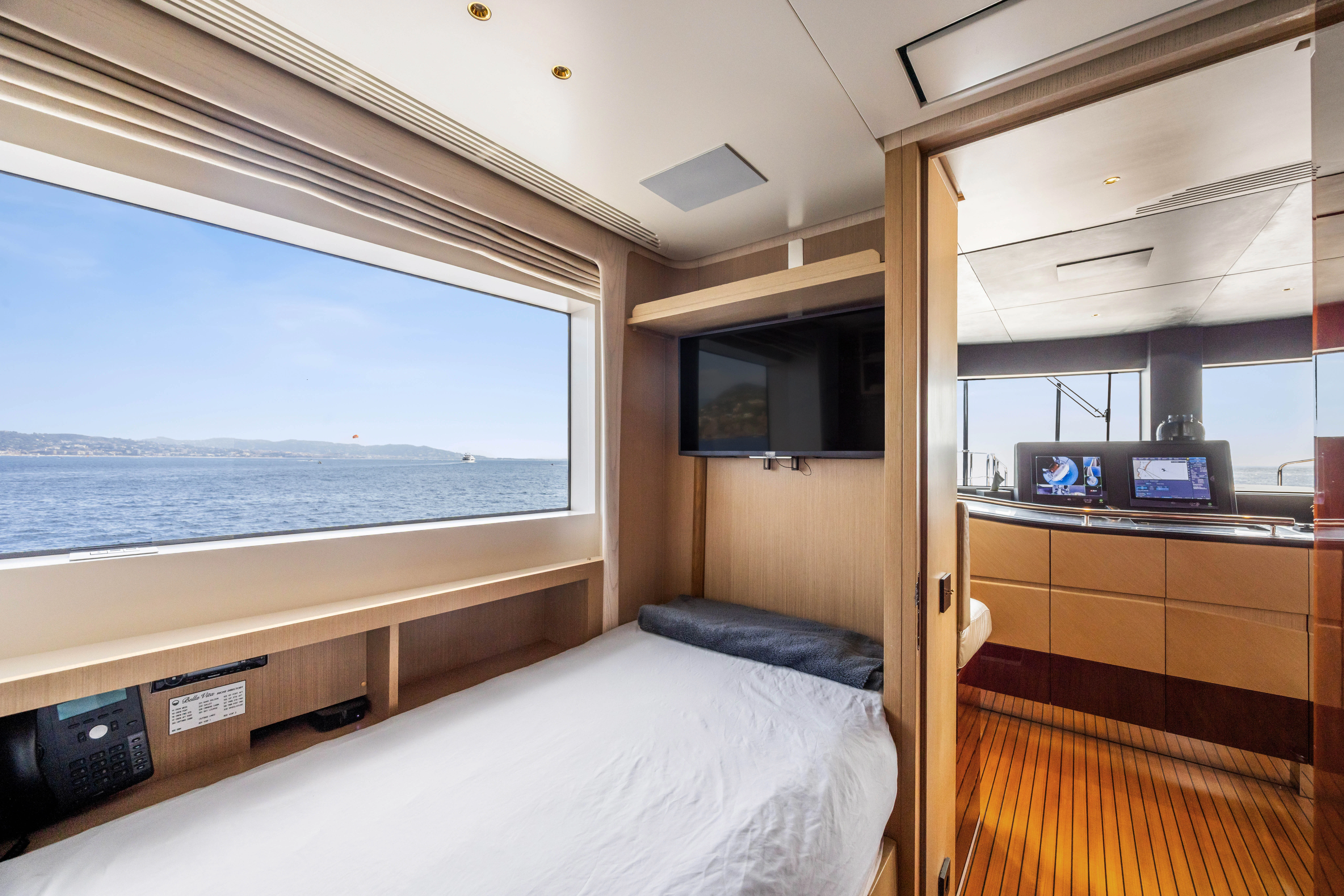 a room with a bed and a television aboard TRAMONTO Yacht for Charter