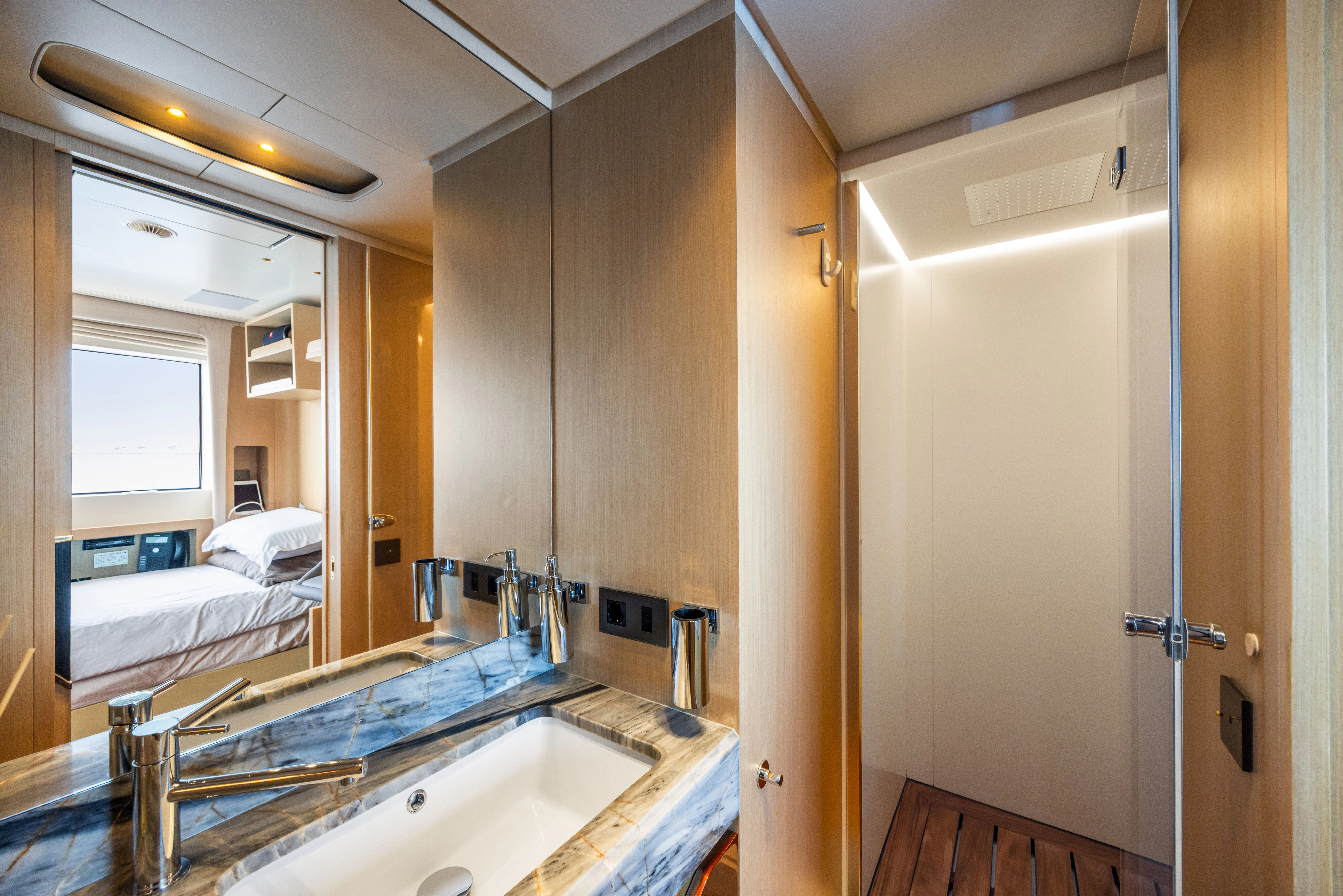 a bathroom with a sink and a bed aboard TRAMONTO Yacht for Charter