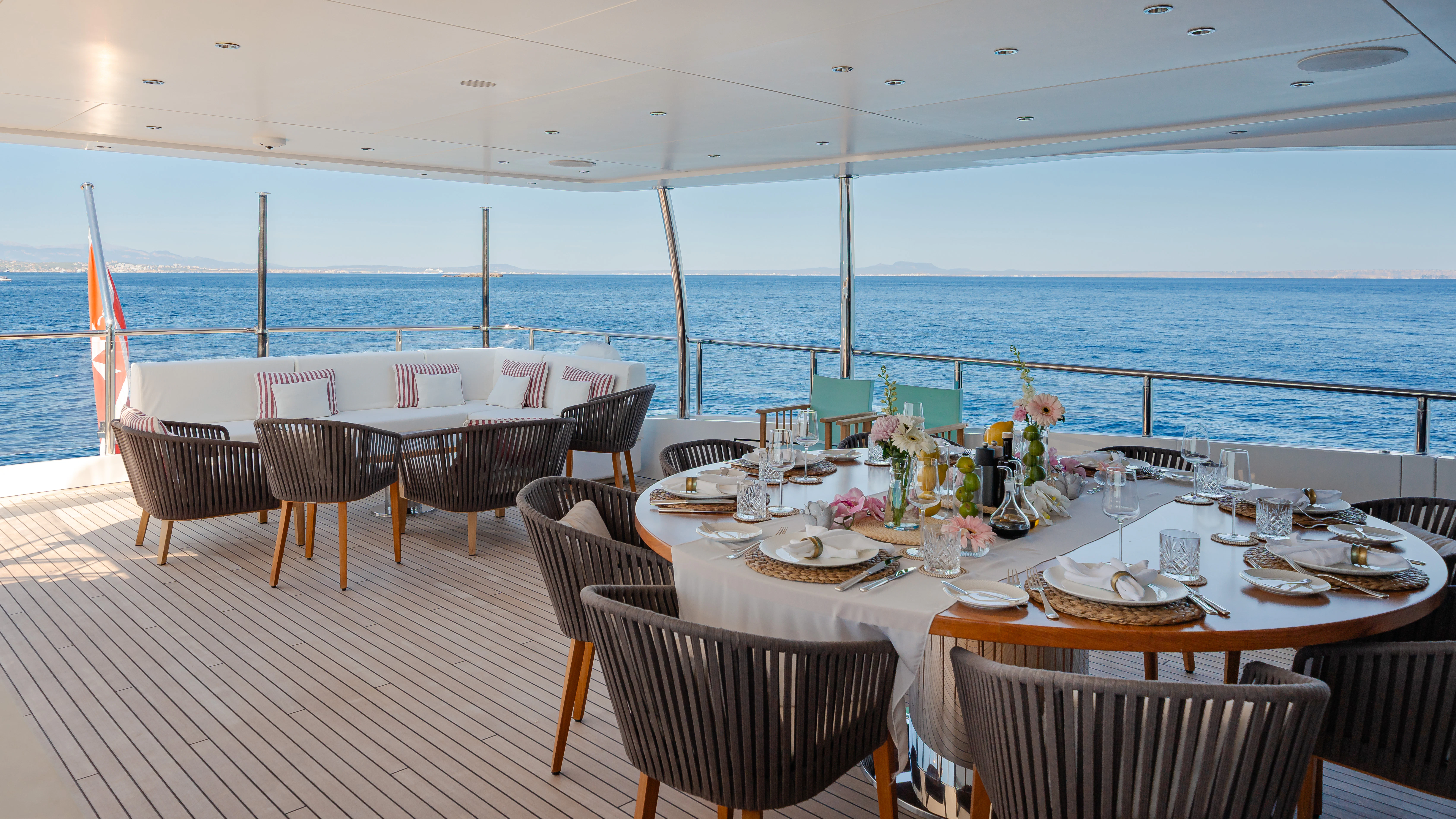 a table set for a meal on a deck overlooking the ocean aboard TRAMONTO Yacht for Charter