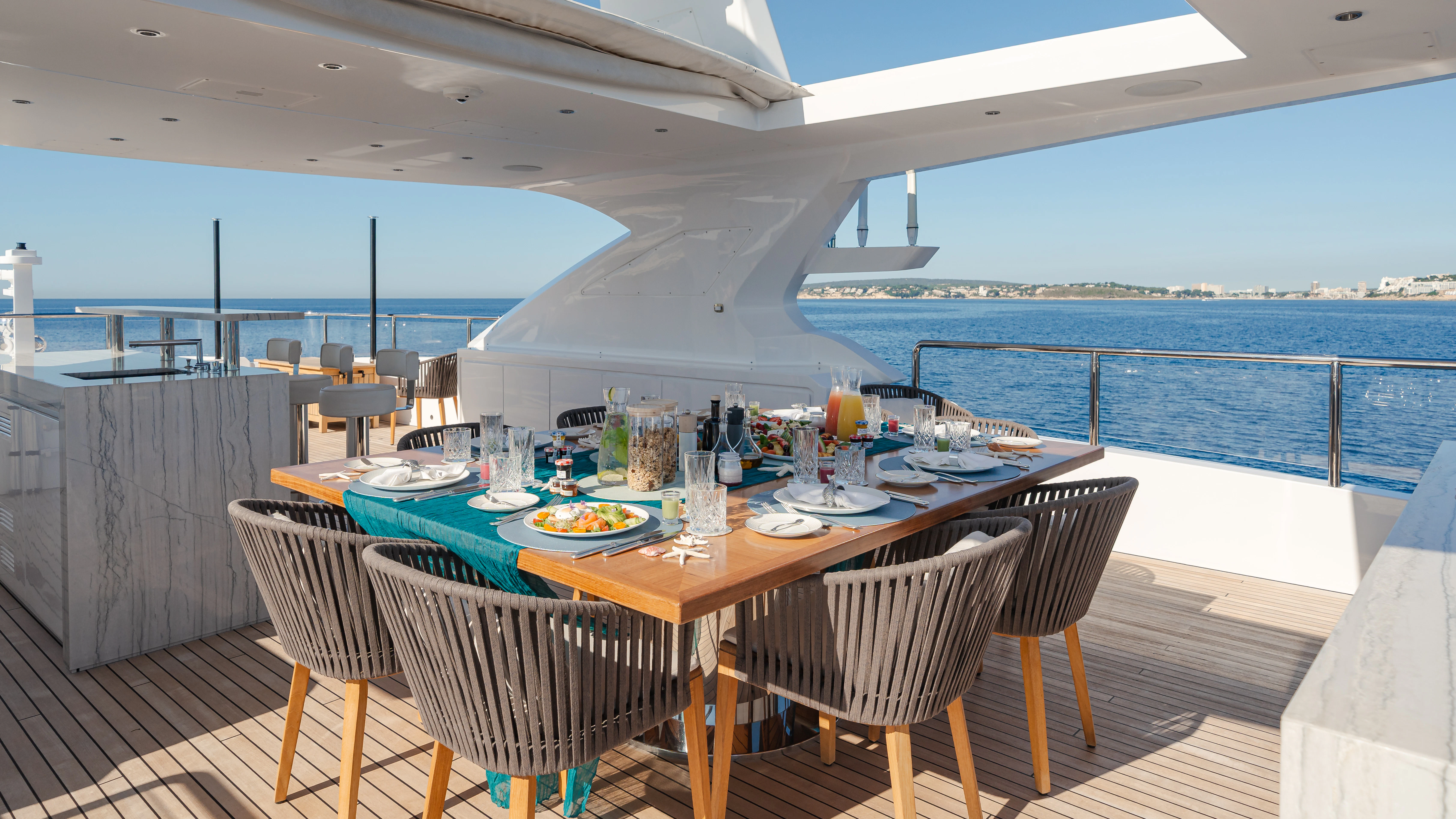 a table set for a meal on a deck overlooking the ocean aboard TRAMONTO Yacht for Charter