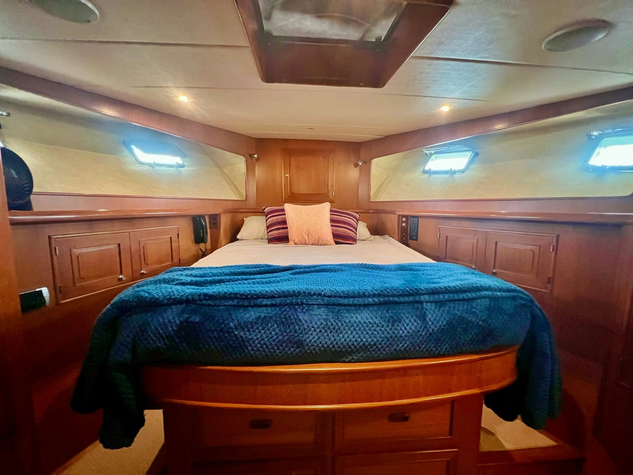 a bed with a blue comforter aboard SYNERGY Yacht for Sale
