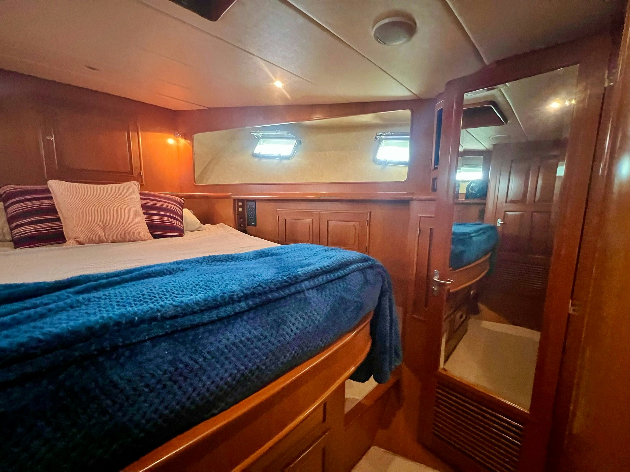 a bed with a blue comforter aboard SYNERGY Yacht for Sale