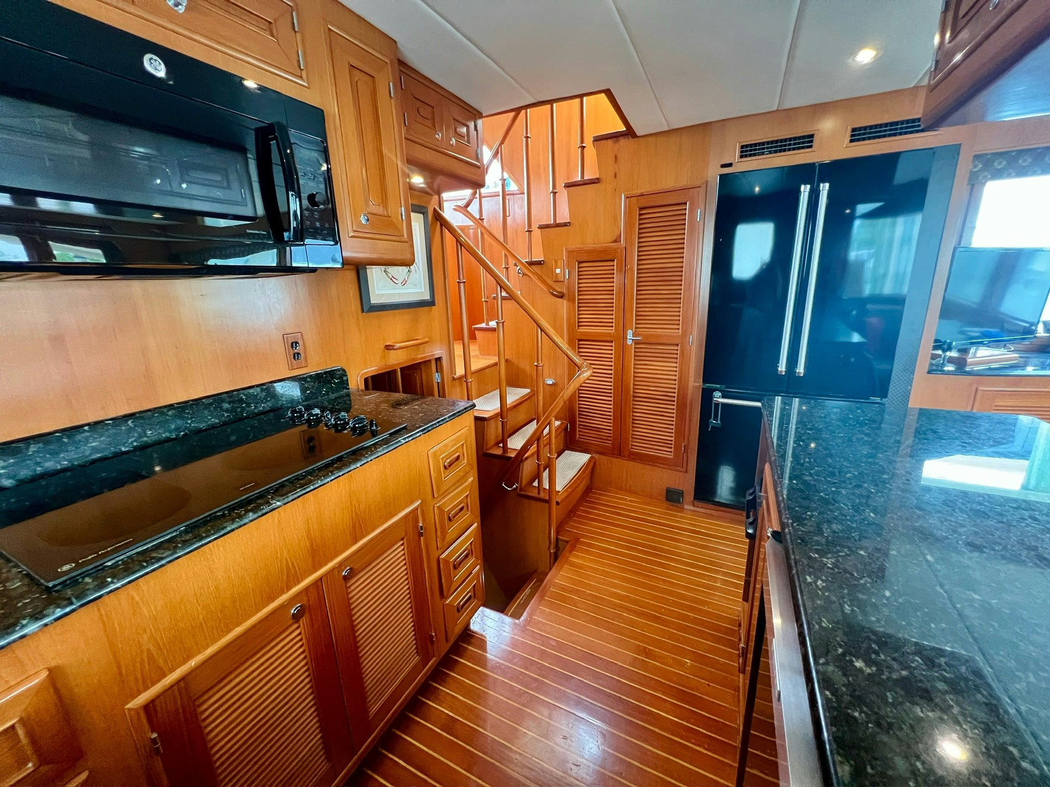 a kitchen with wooden cabinets aboard SYNERGY Yacht for Sale