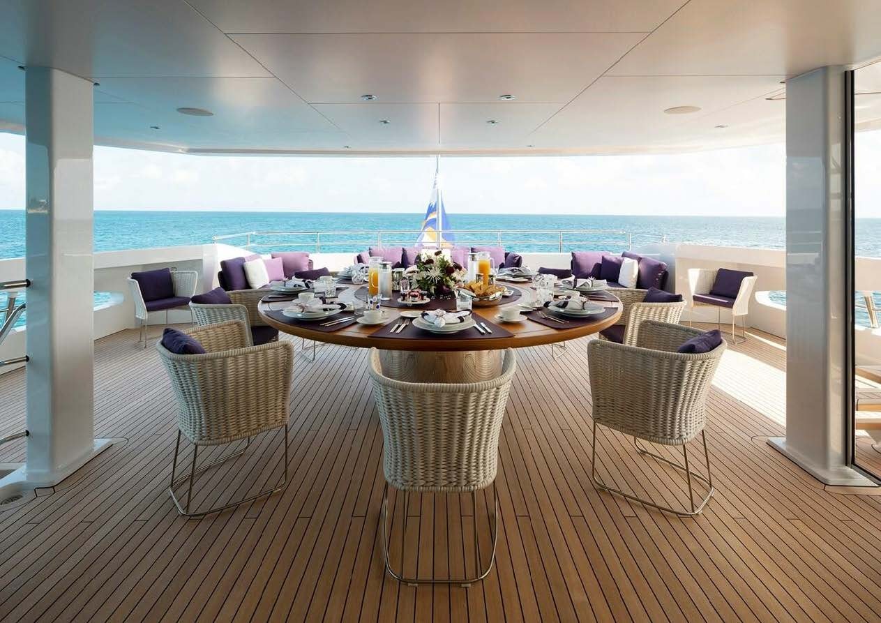a room with tables and chairs aboard ELA Yacht for Sale