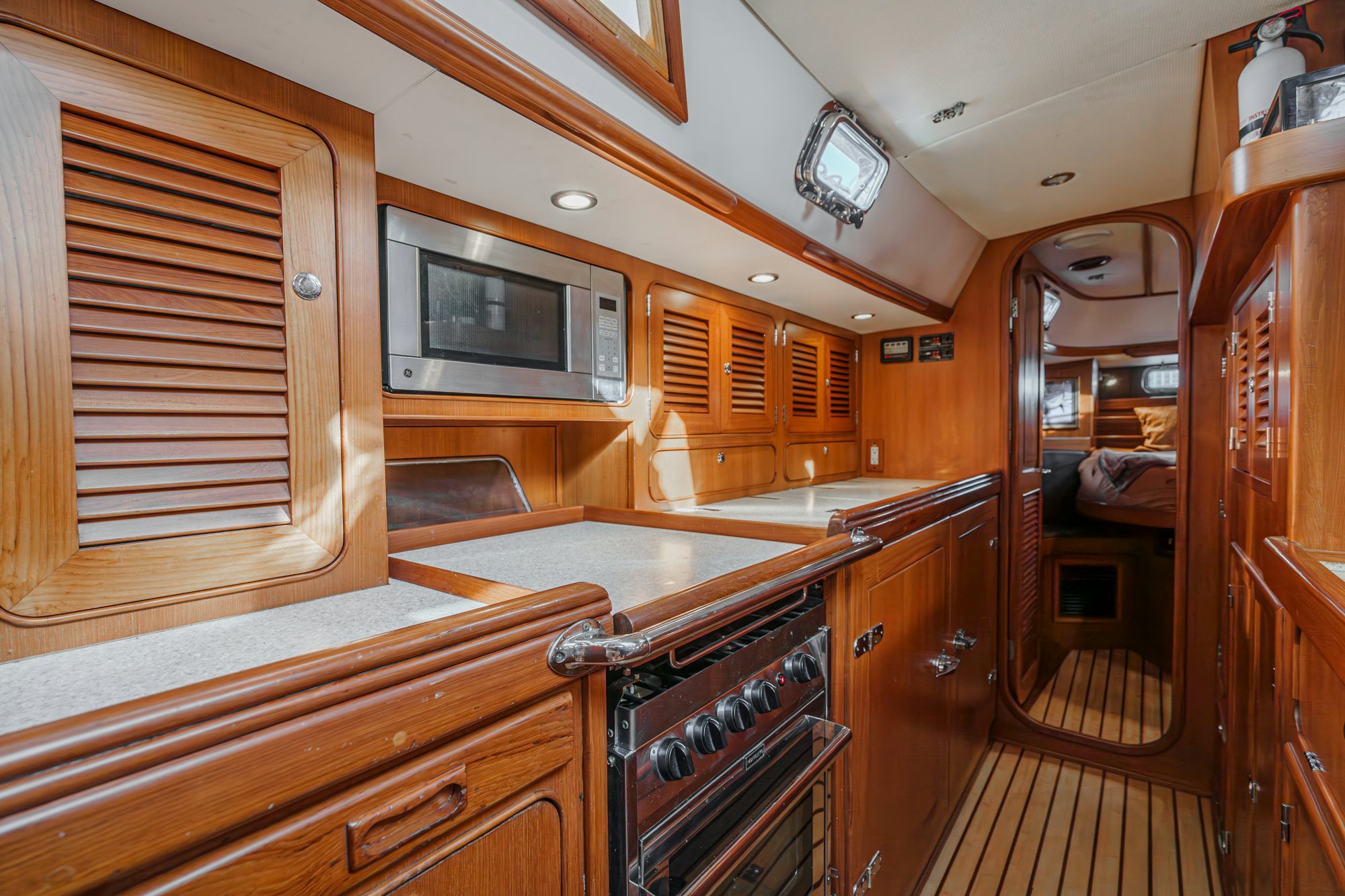 a kitchen with wooden cabinets aboard FEATHER Yacht for Sale