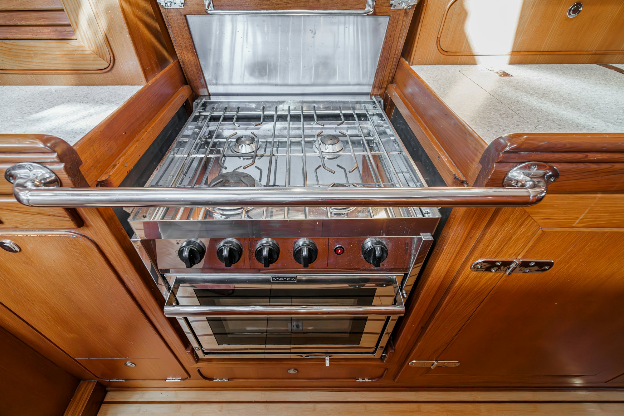 a kitchen with a stove and a wood cabinet aboard FEATHER Yacht for Sale