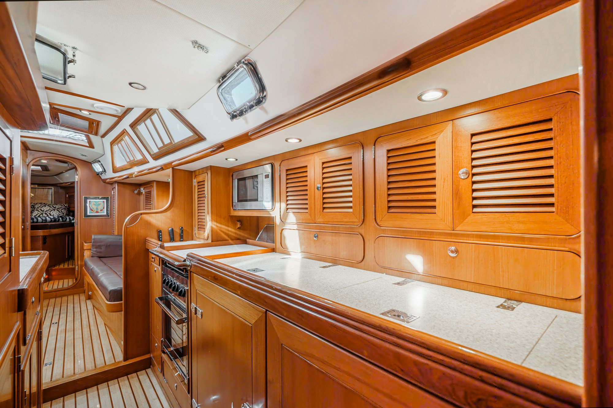 a kitchen with wooden cabinets aboard FEATHER Yacht for Sale
