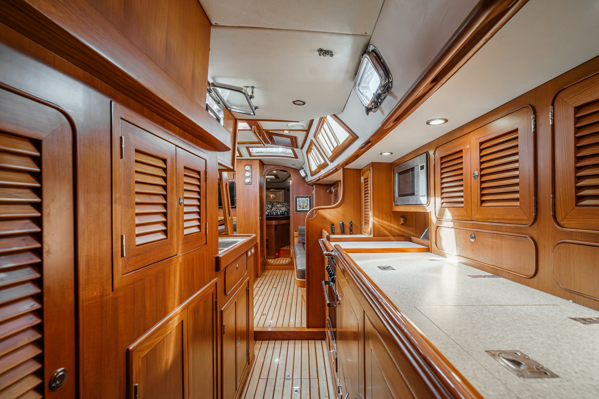a kitchen with wooden cabinets aboard FEATHER Yacht for Sale