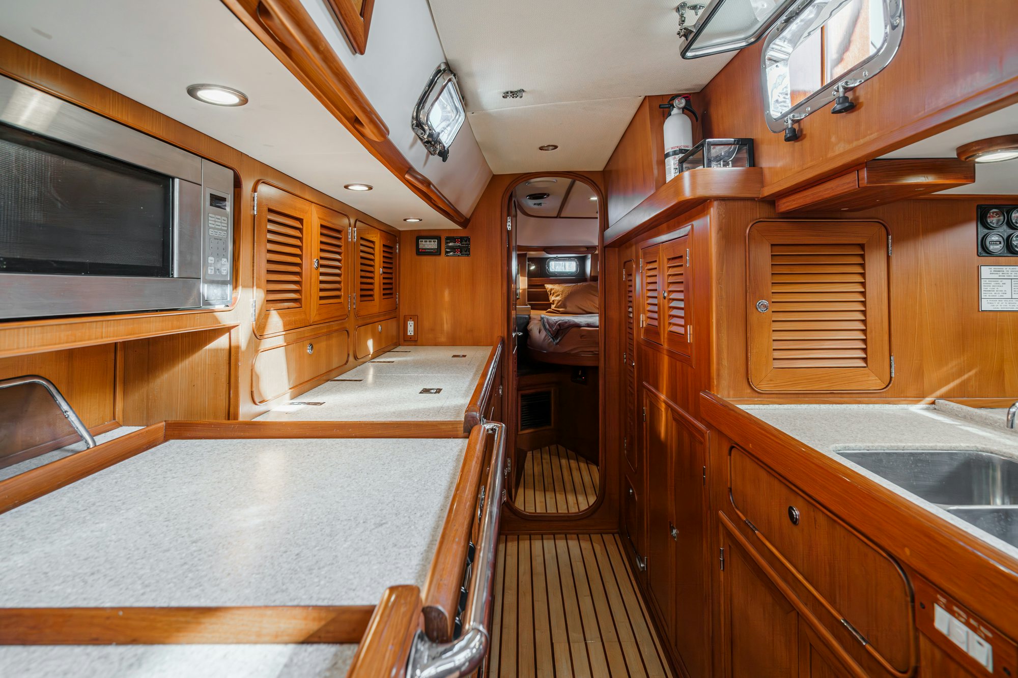 a kitchen with wooden cabinets aboard FEATHER Yacht for Sale
