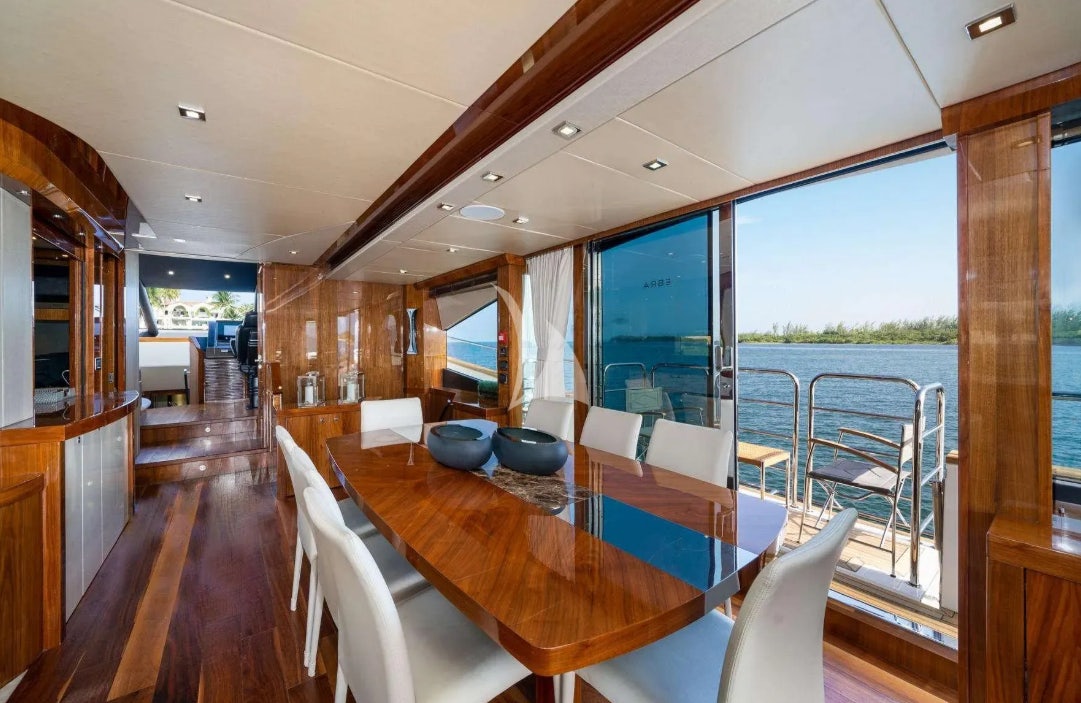a large room with a table and chairs aboard OASIS Yacht for Charter