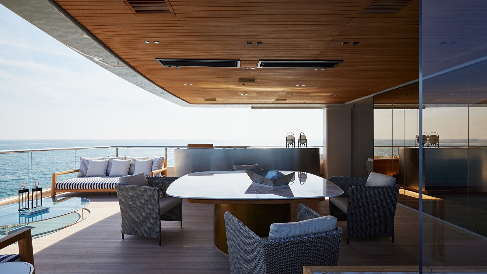 a modern living room with a large table and chairs aboard LA LA LAND Yacht for Charter