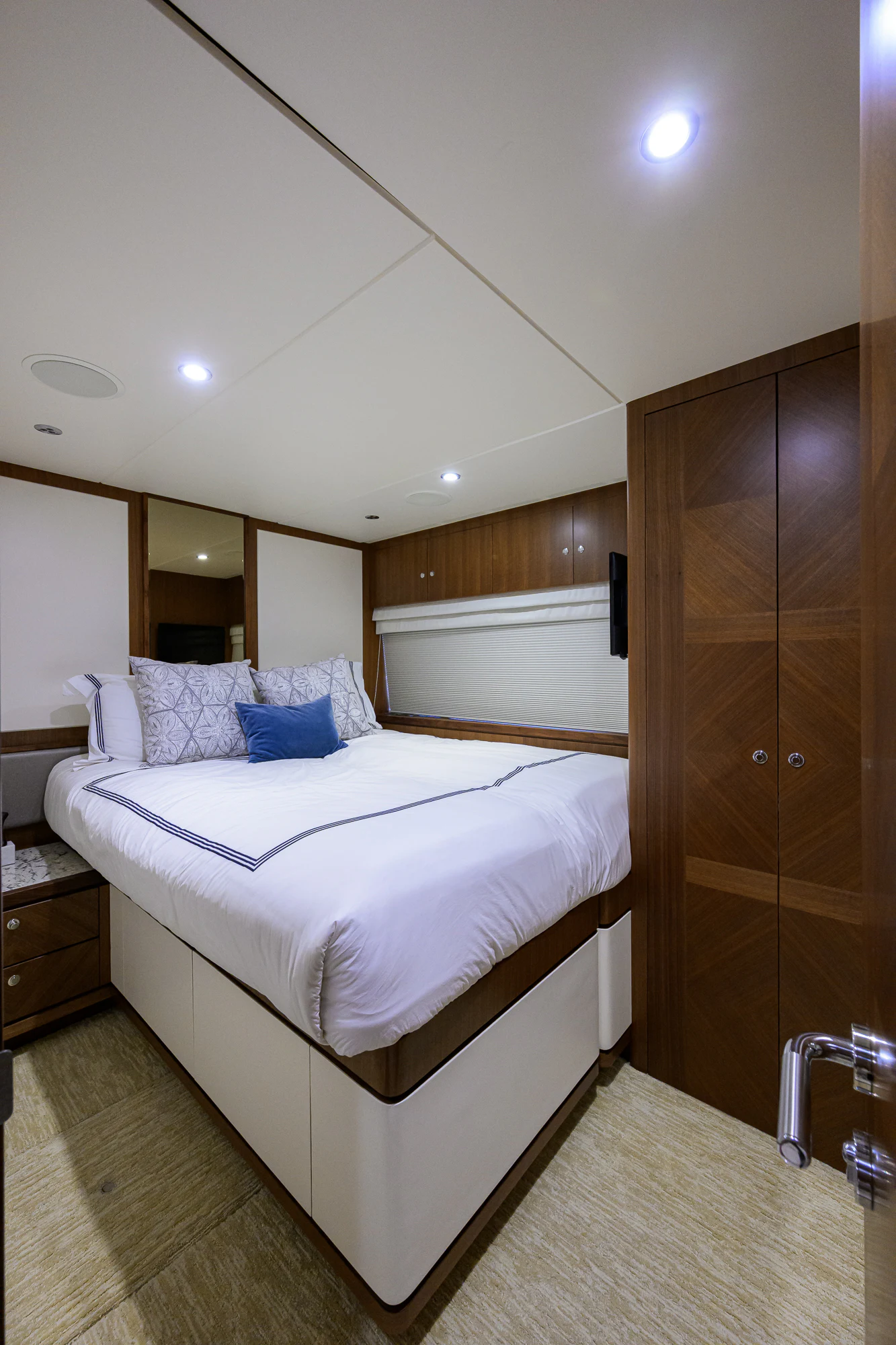 a bed with a white sheet and a wooden cabinet aboard CHINDON Yacht for Sale