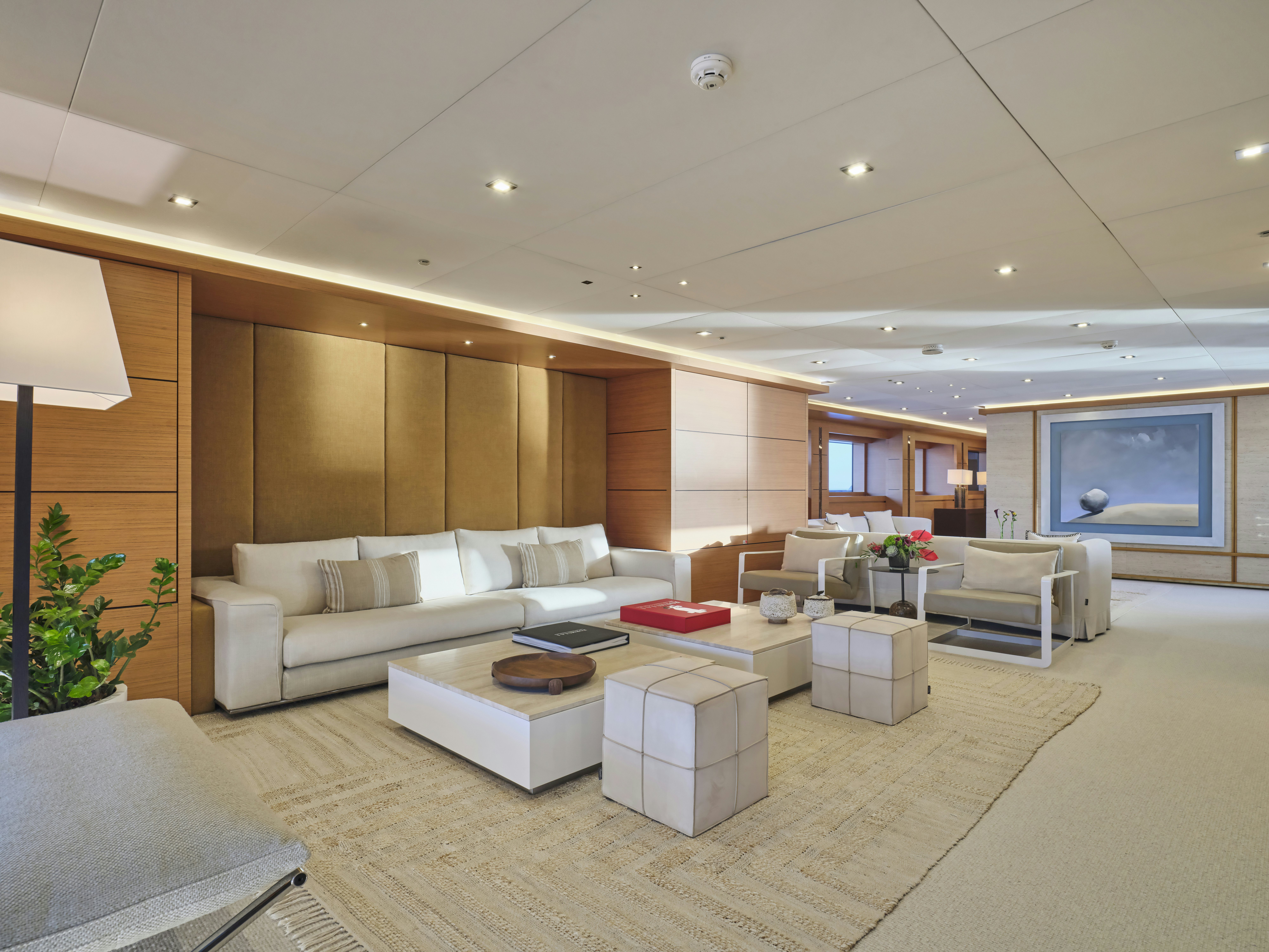 a living room with a large white couch and a large mirror aboard PERSEFONI I Yacht for Charter