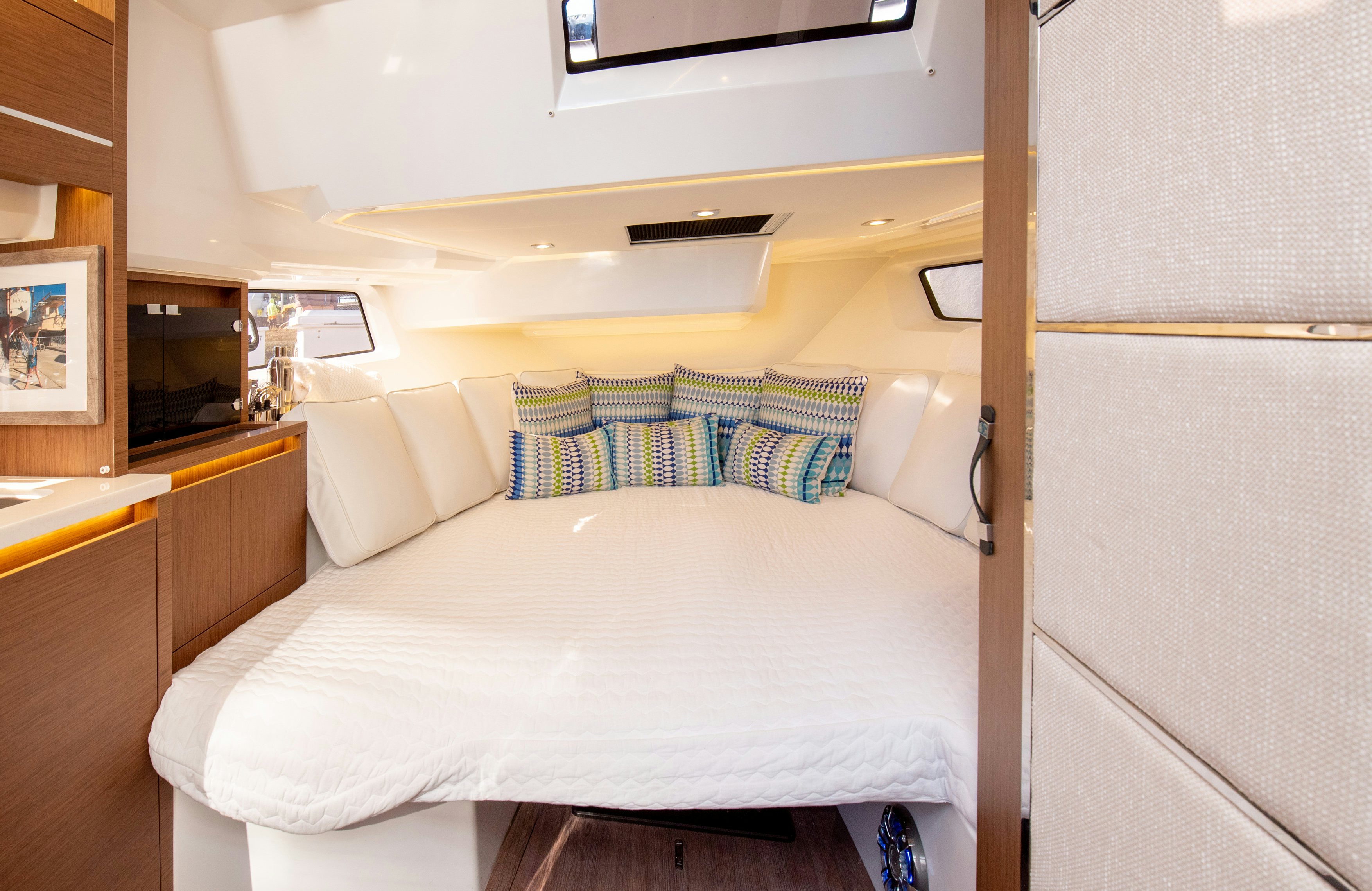 a bed with a white sheet and blue and white striped pillows aboard NAUTI BRIGI GULL Yacht for Sale