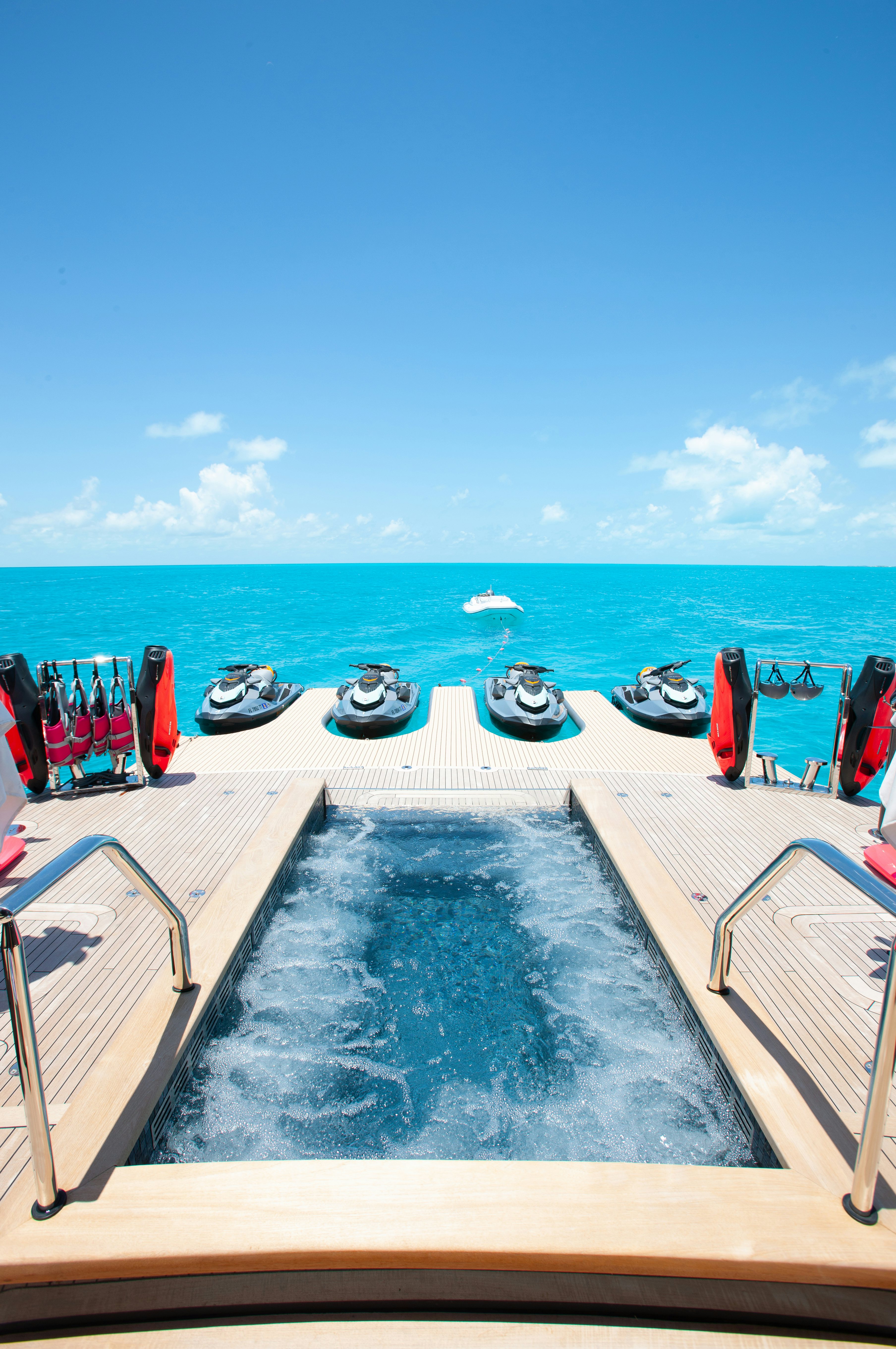 a deck with a pool and boats on it aboard NO BAD IDEAS Yacht for Sale