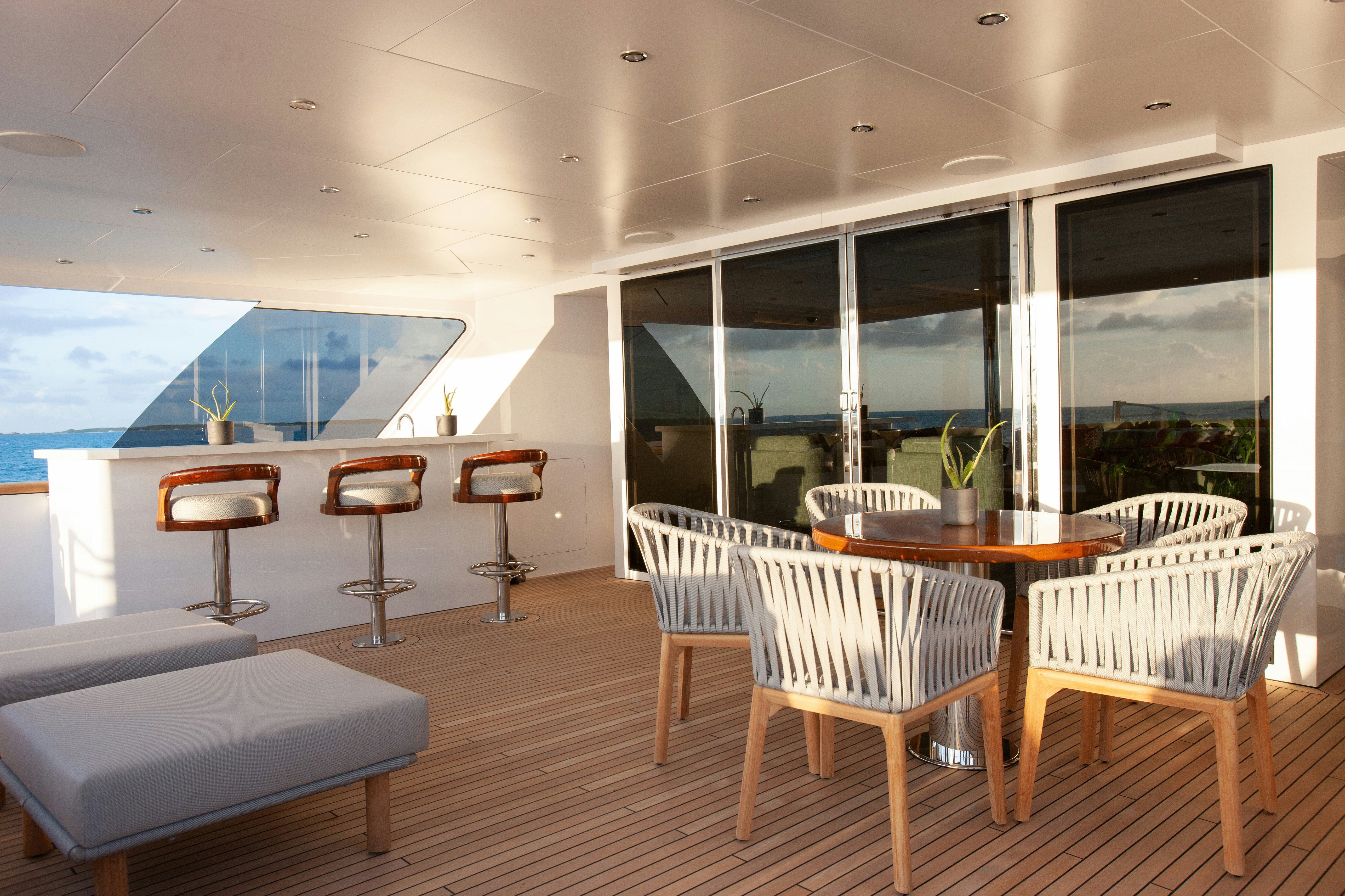 a room with tables and chairs aboard NO BAD IDEAS Yacht for Sale