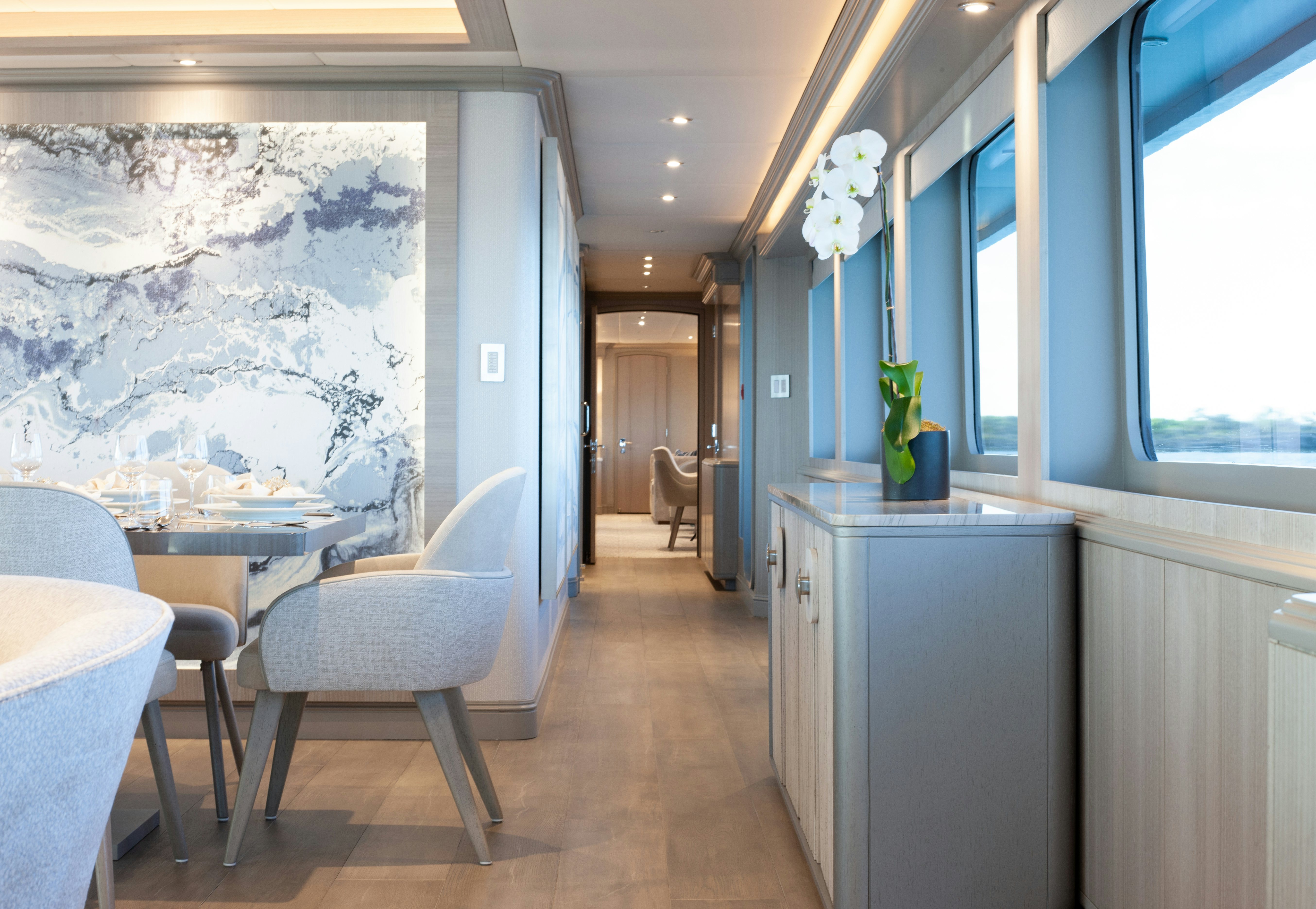 a room with a table chairs and a large painting aboard NO BAD IDEAS Yacht for Sale