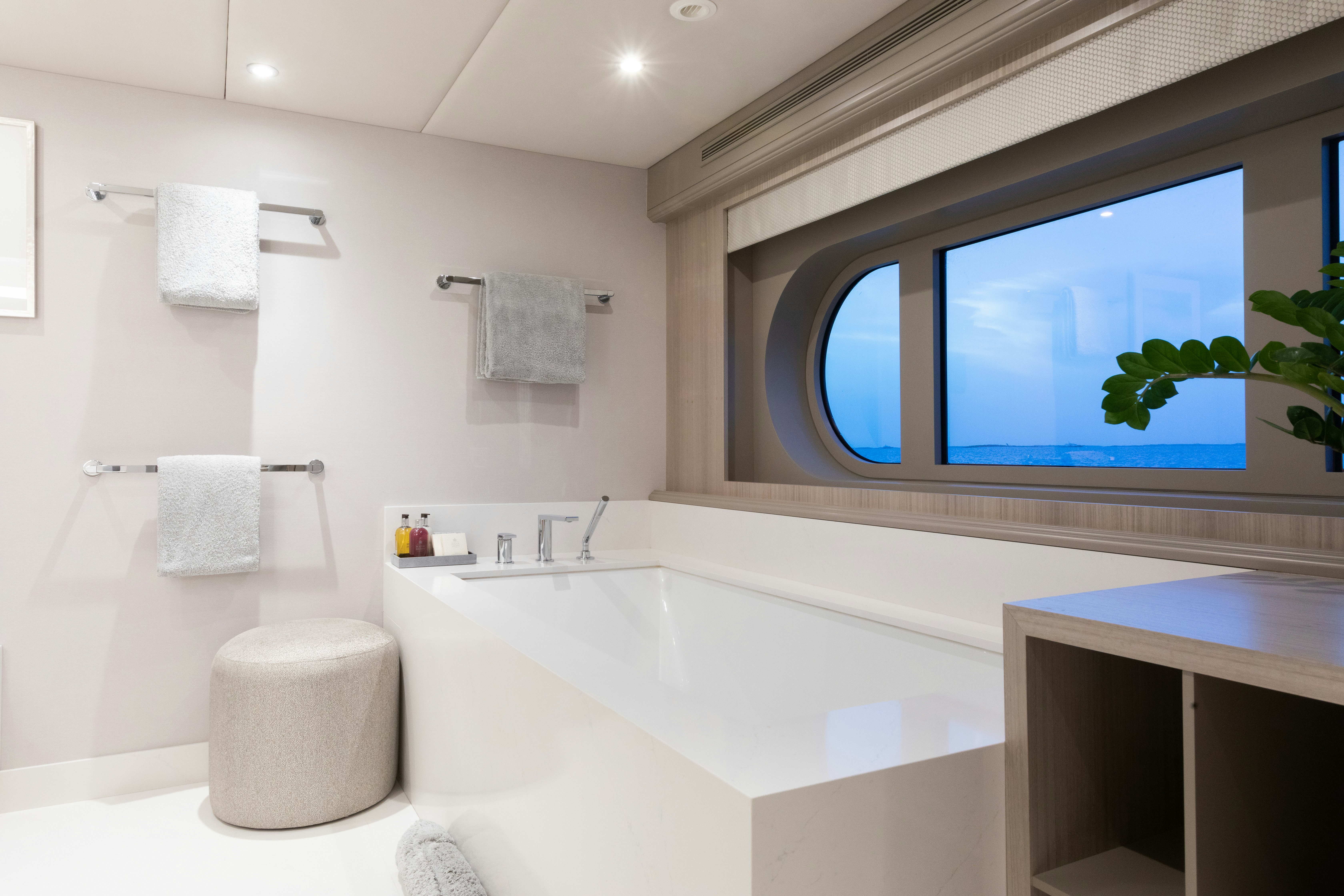 a bathroom with a tub sink and a mirror aboard NO BAD IDEAS Yacht for Sale